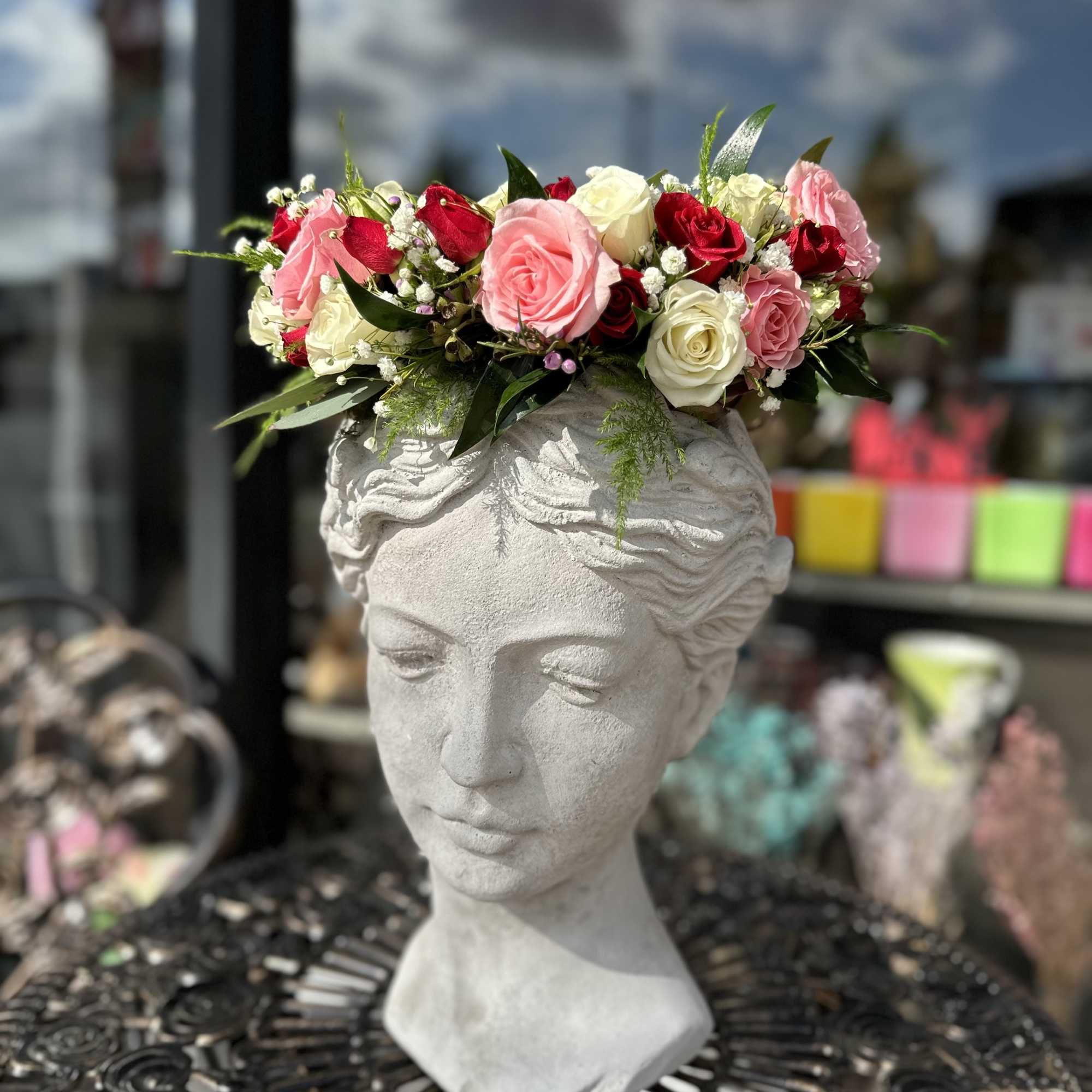 Pink and white rose crown on a stone bust planter