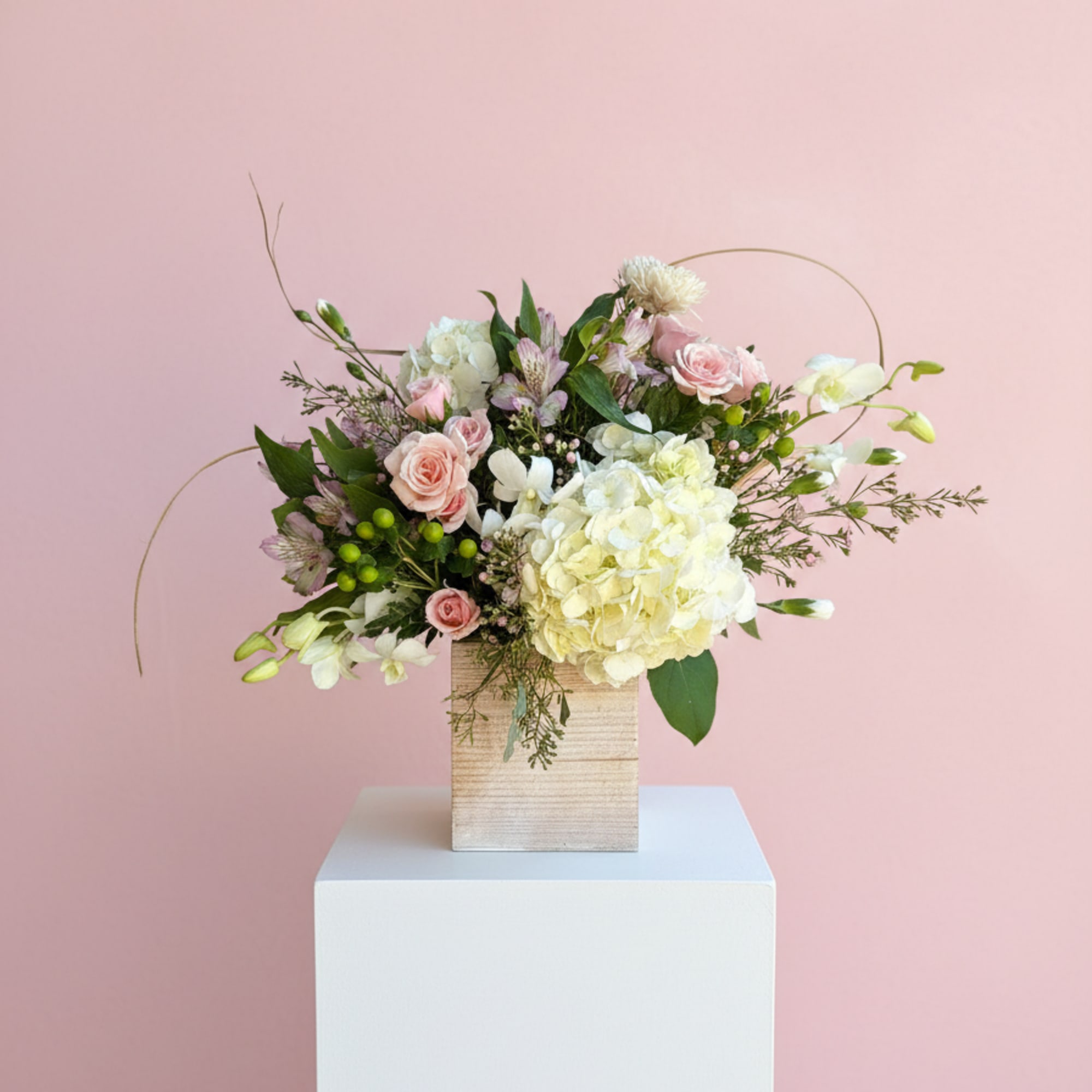 Pink and white floral arrangement in a wooden box
