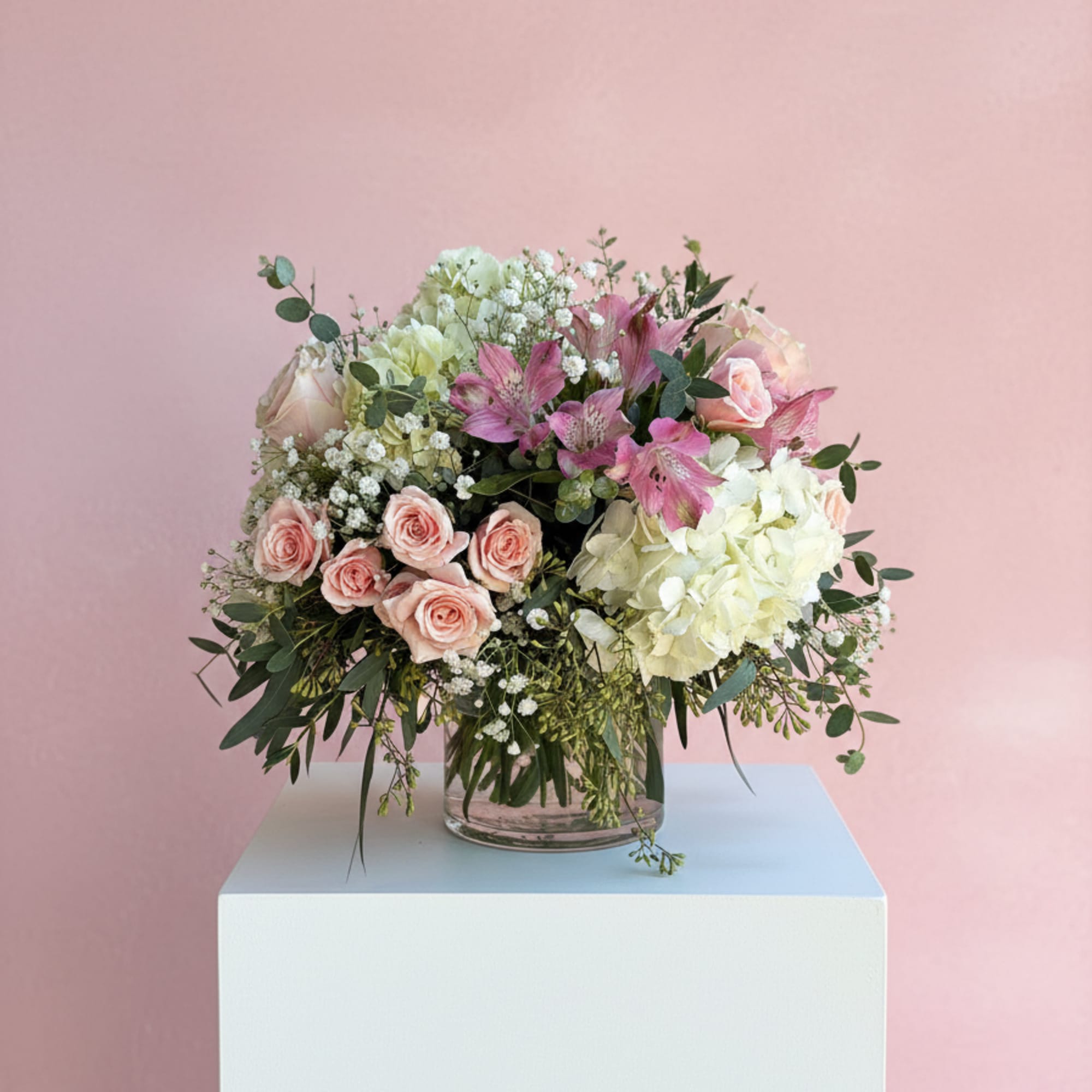 Pink and white floral arrangement in a clear glass vase