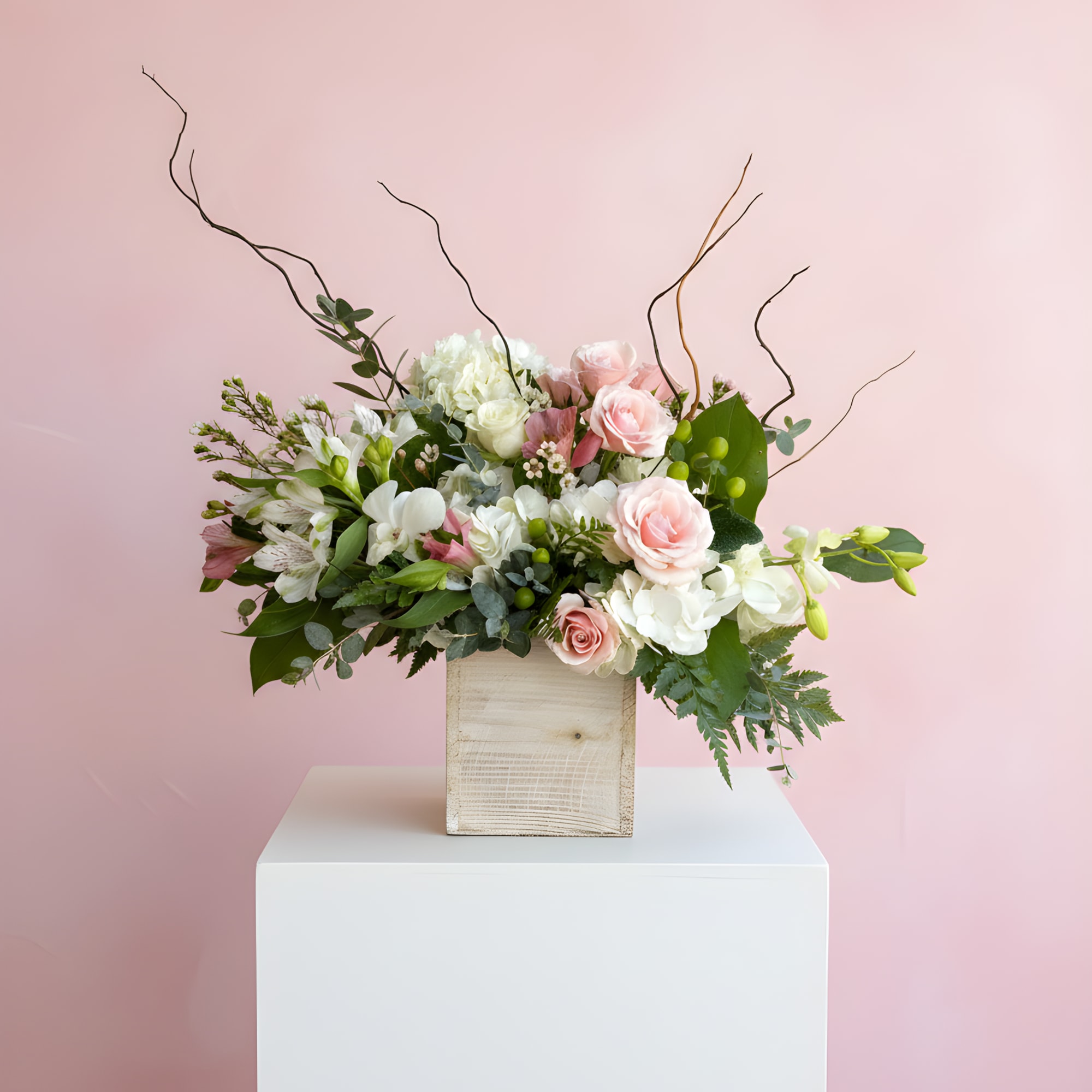 Pink and white floral arrangement in a wooden box