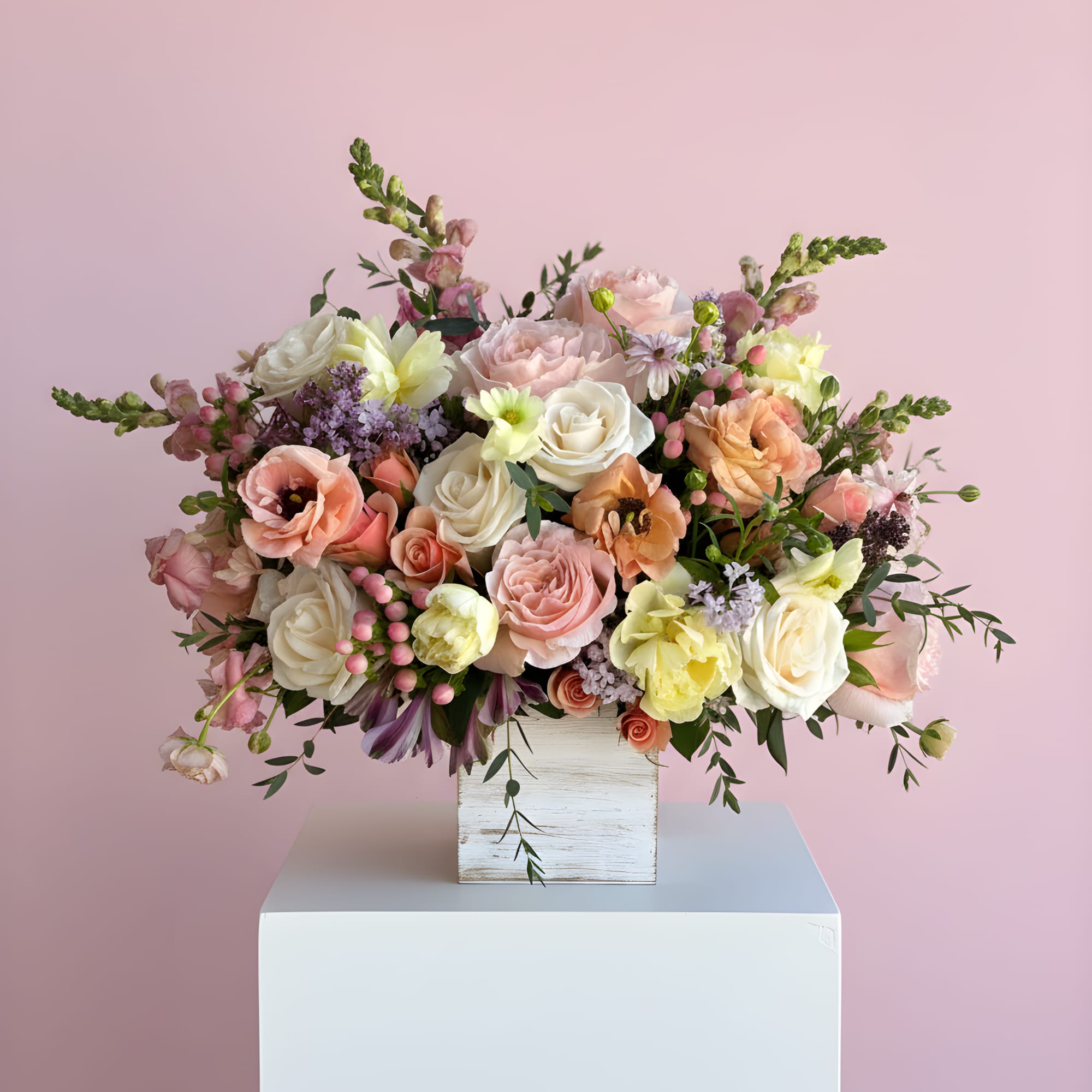 This arrangement has a soft, romantic garden style with a color palette