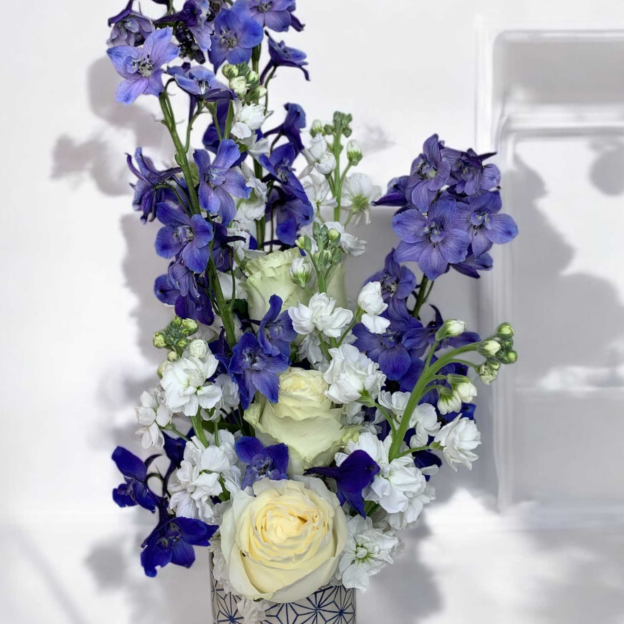 Blue and white floral arrangement in a patterned vase