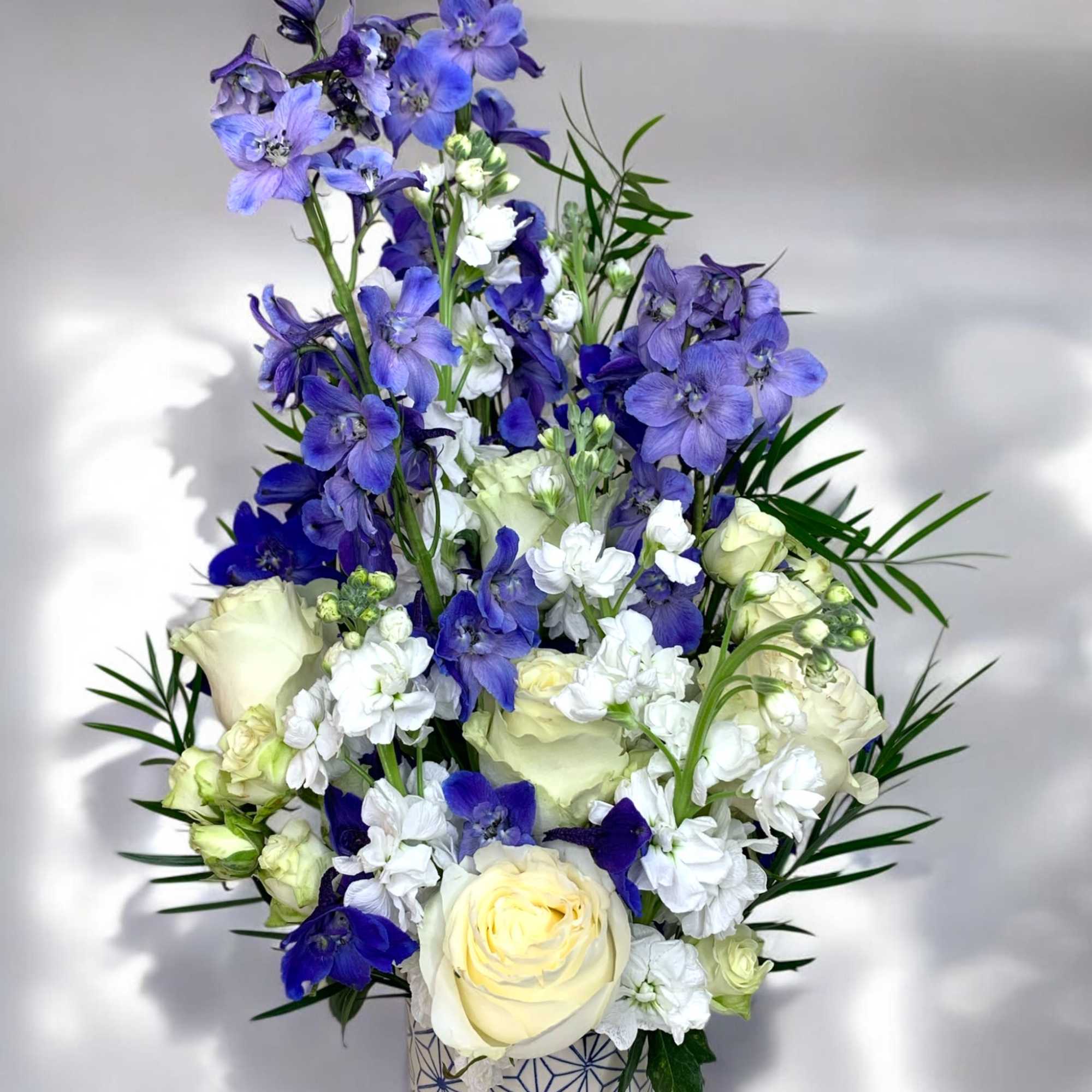 Blue and white floral arrangement in a patterned vase