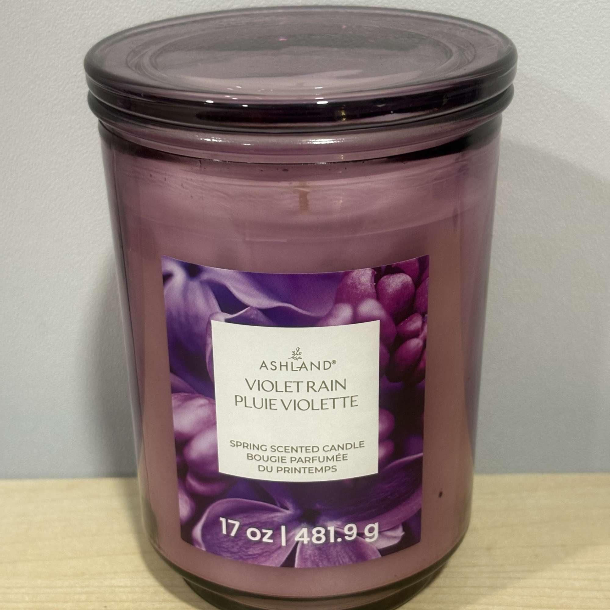 Purple scented candle in a glass jar with a lid