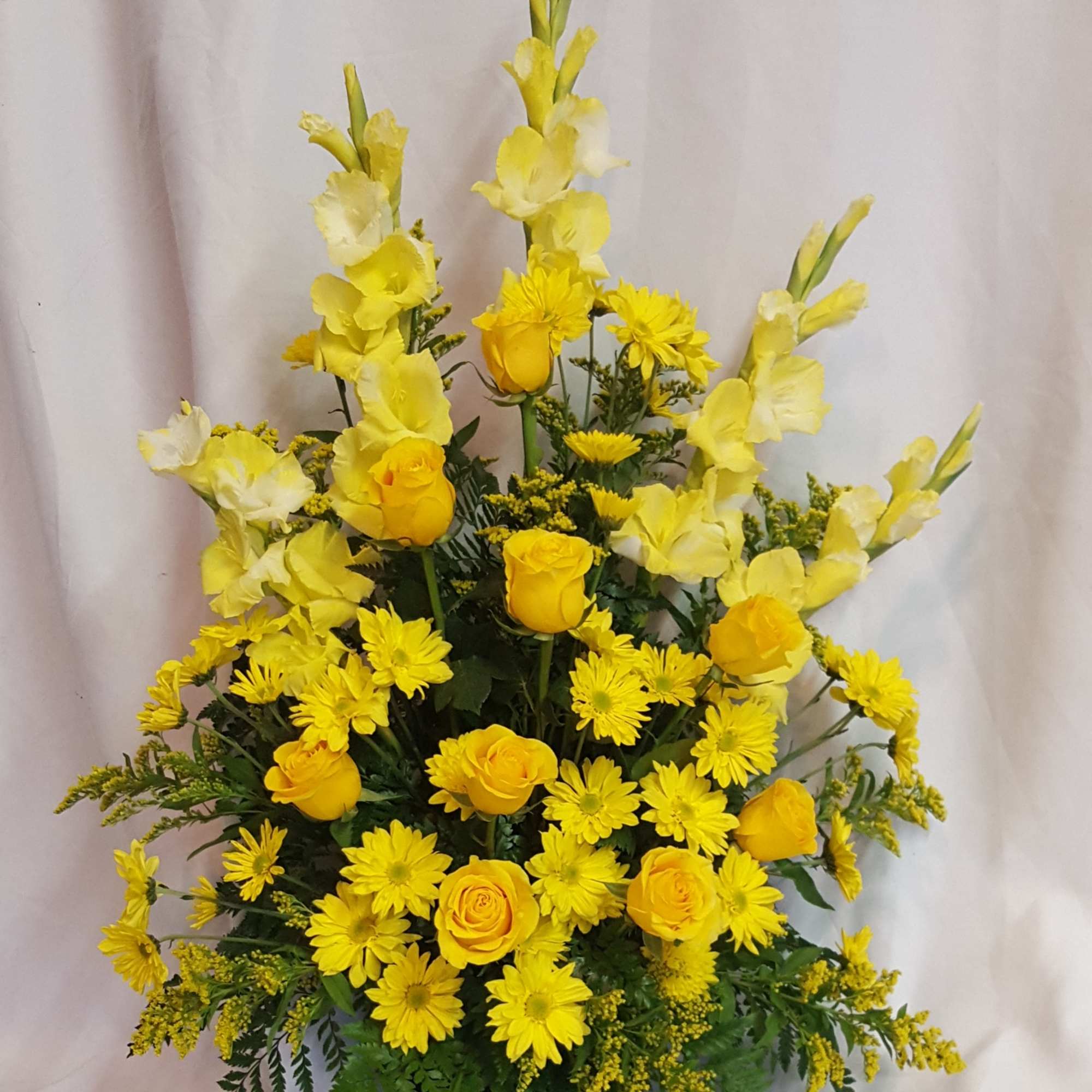 Yellow roses and daisies arranged in a black vase