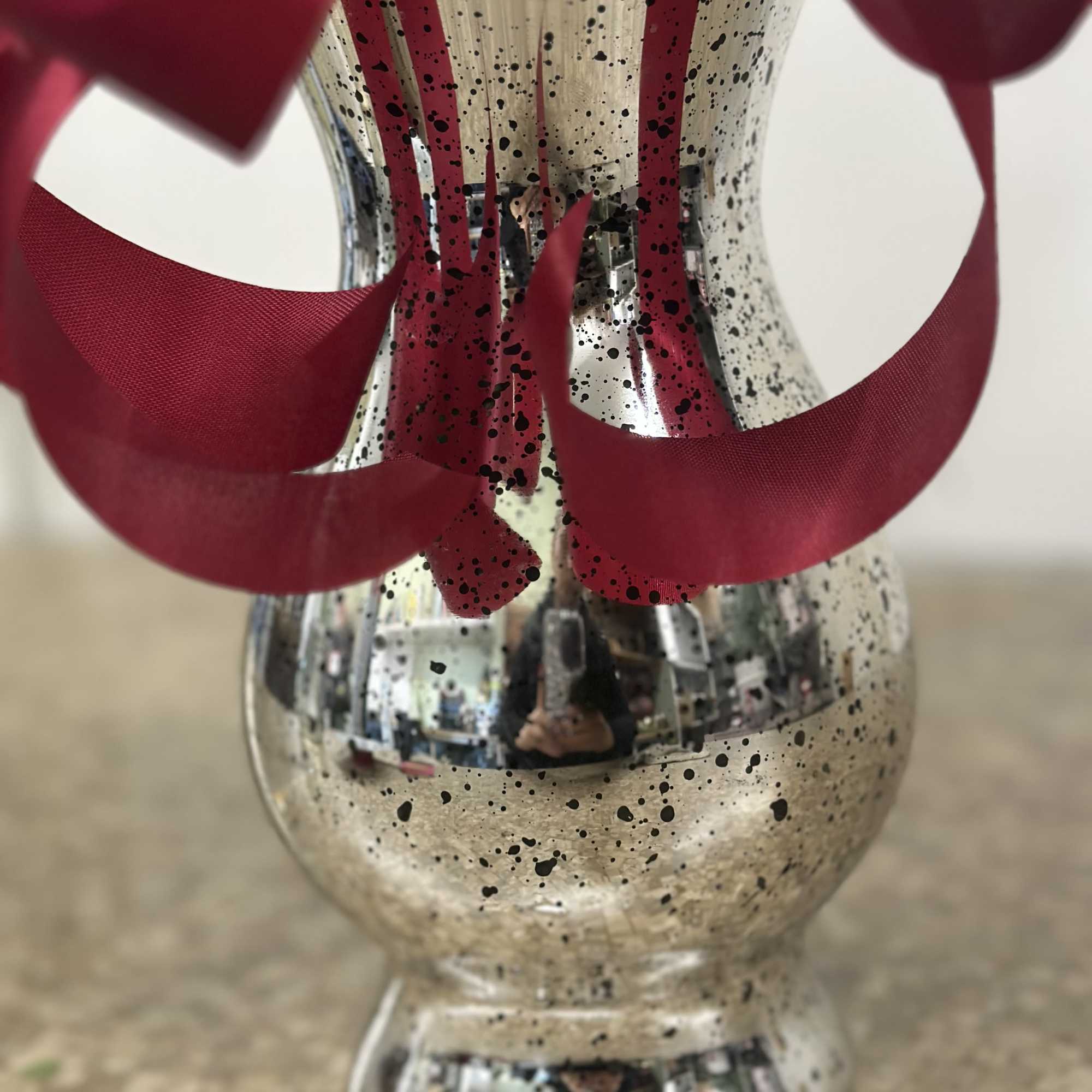 Silver speckled vase with red ribbon loops