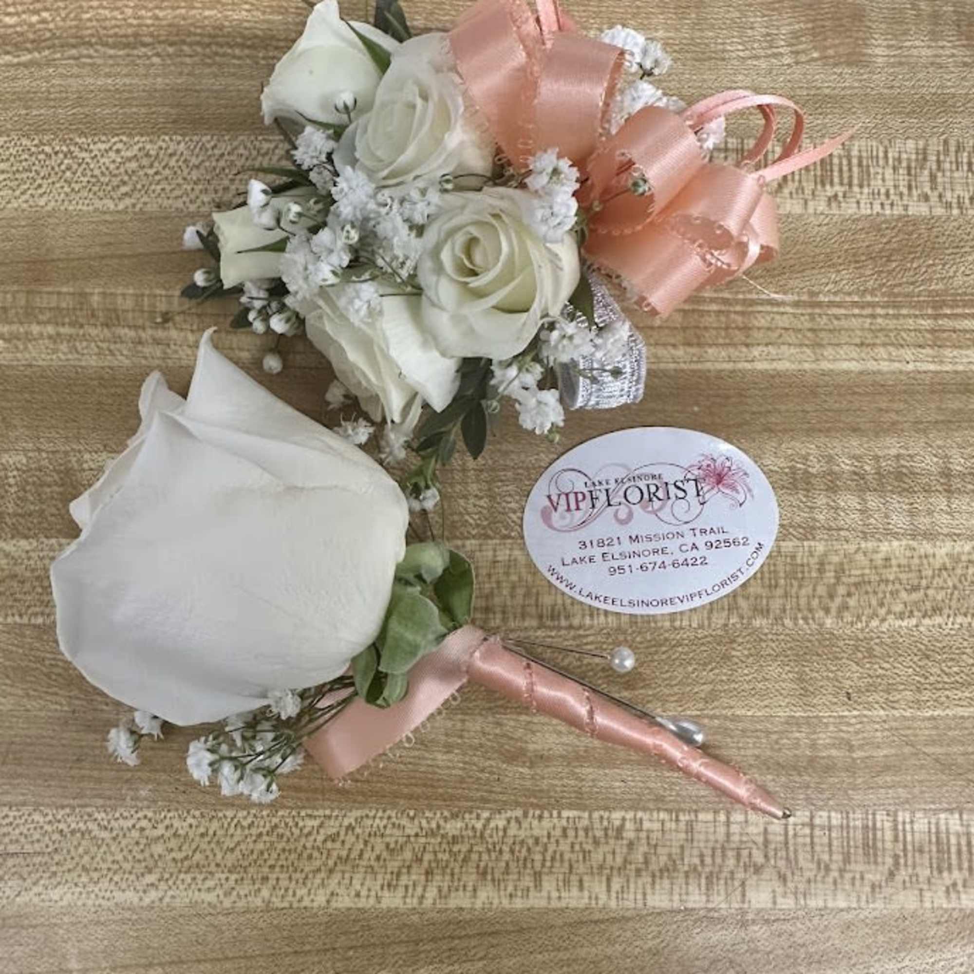 A delicate white rose corsage and matching boutonniere set that reads as, photo 3 of 4