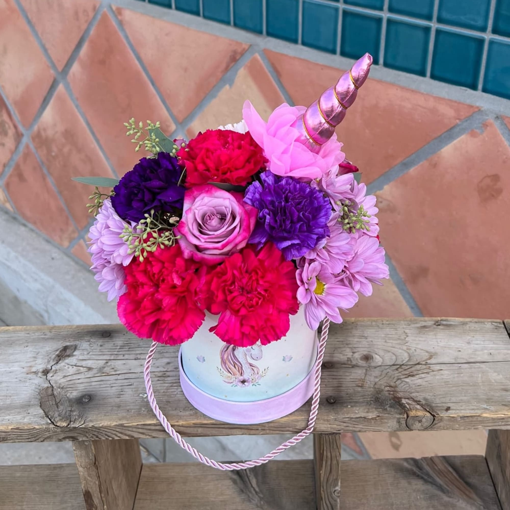 Pink and lavender flowers arranged inside a unicorn box. 
mixed flowers of