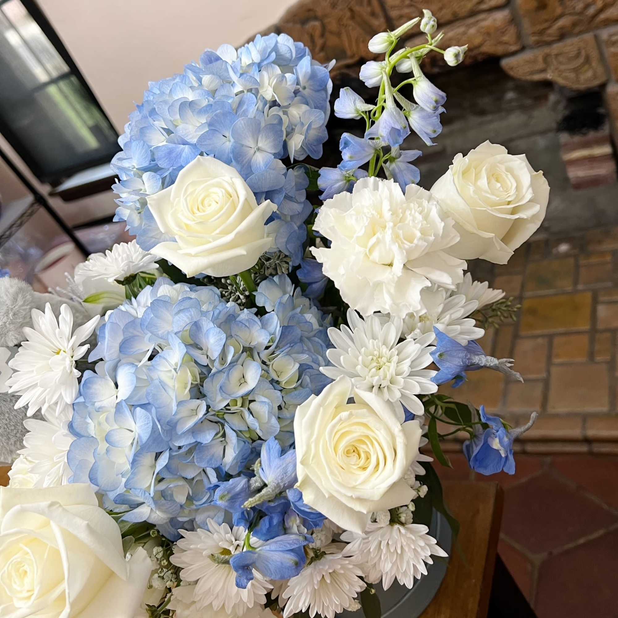 Blue hydrangeas with white roses and daisies in a vase
