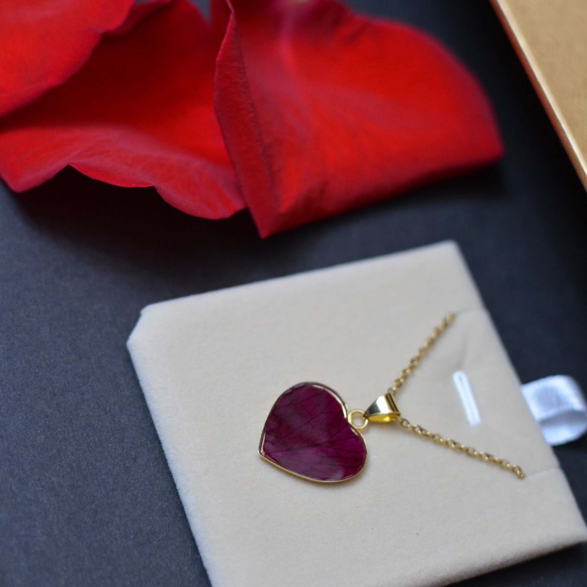 A heart-shaped acrylic jewelry box filled with fresh flowers, cradling a timeless, photo 3 of 3