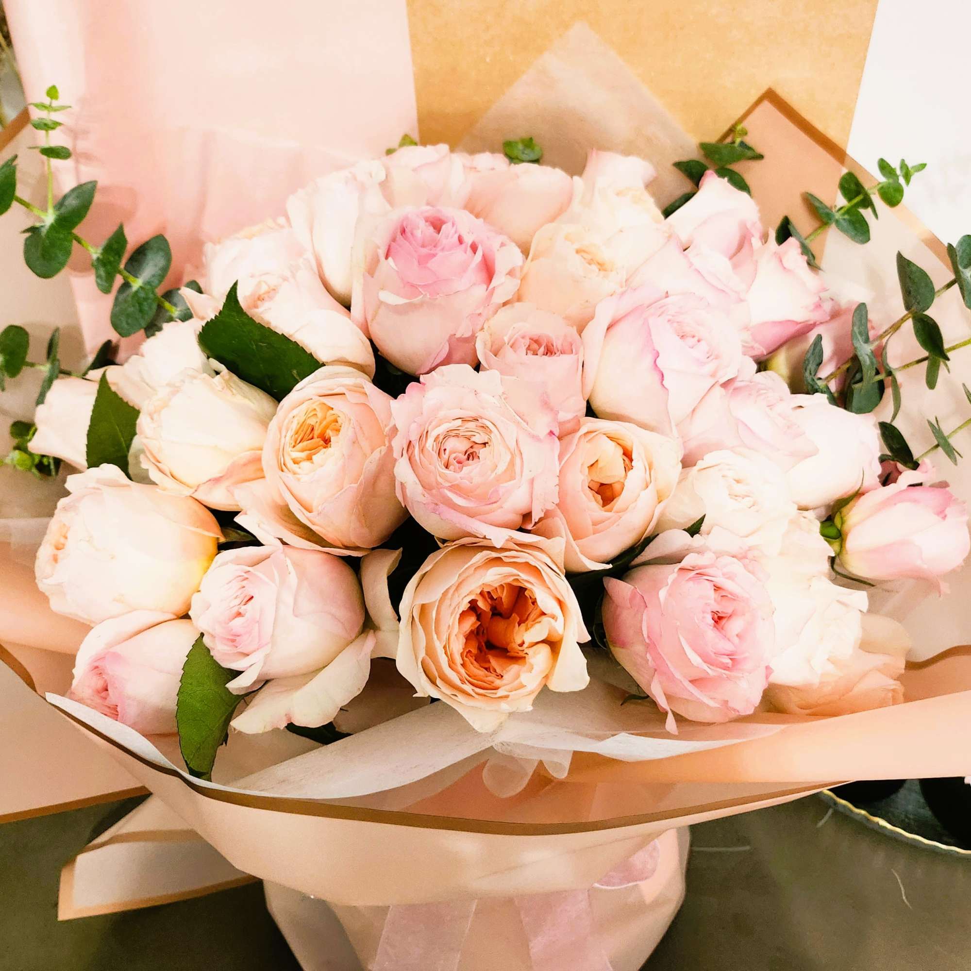 Bouquet of pale pink roses wrapped in blush paper
