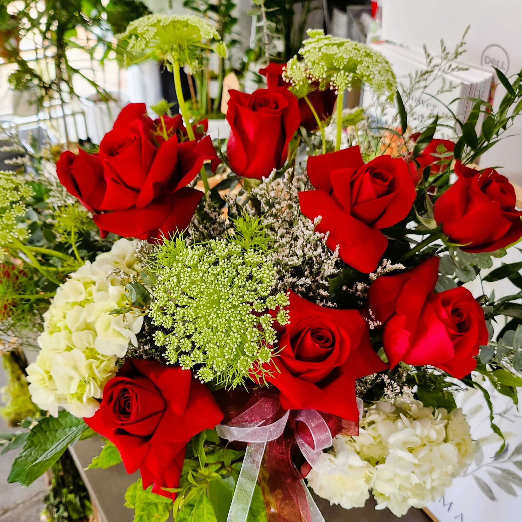 Bouquet of red roses with white hydrangeas and green filler flowers