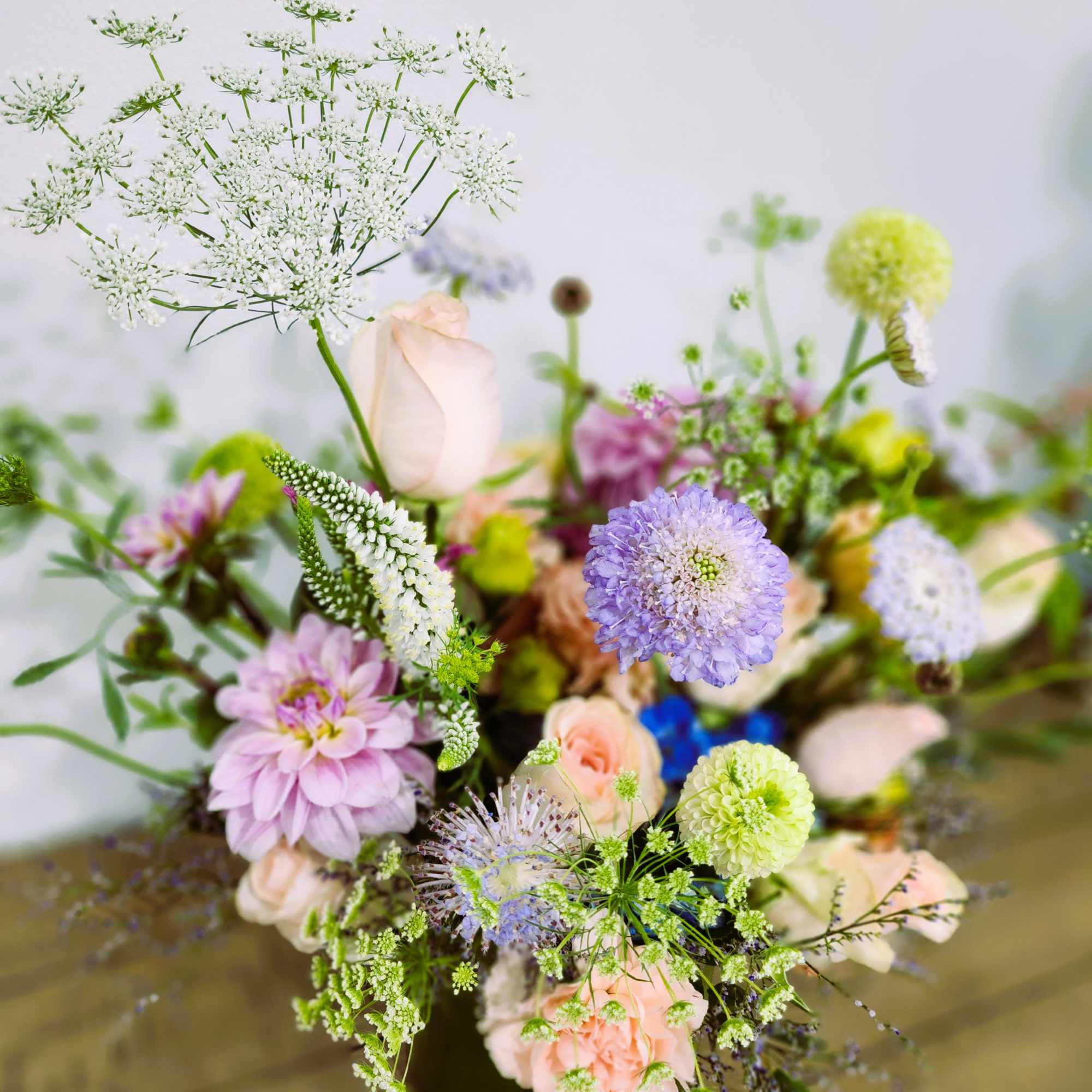 Loose pastel bouquet with white lace flowers, lavender blooms, and peach roses