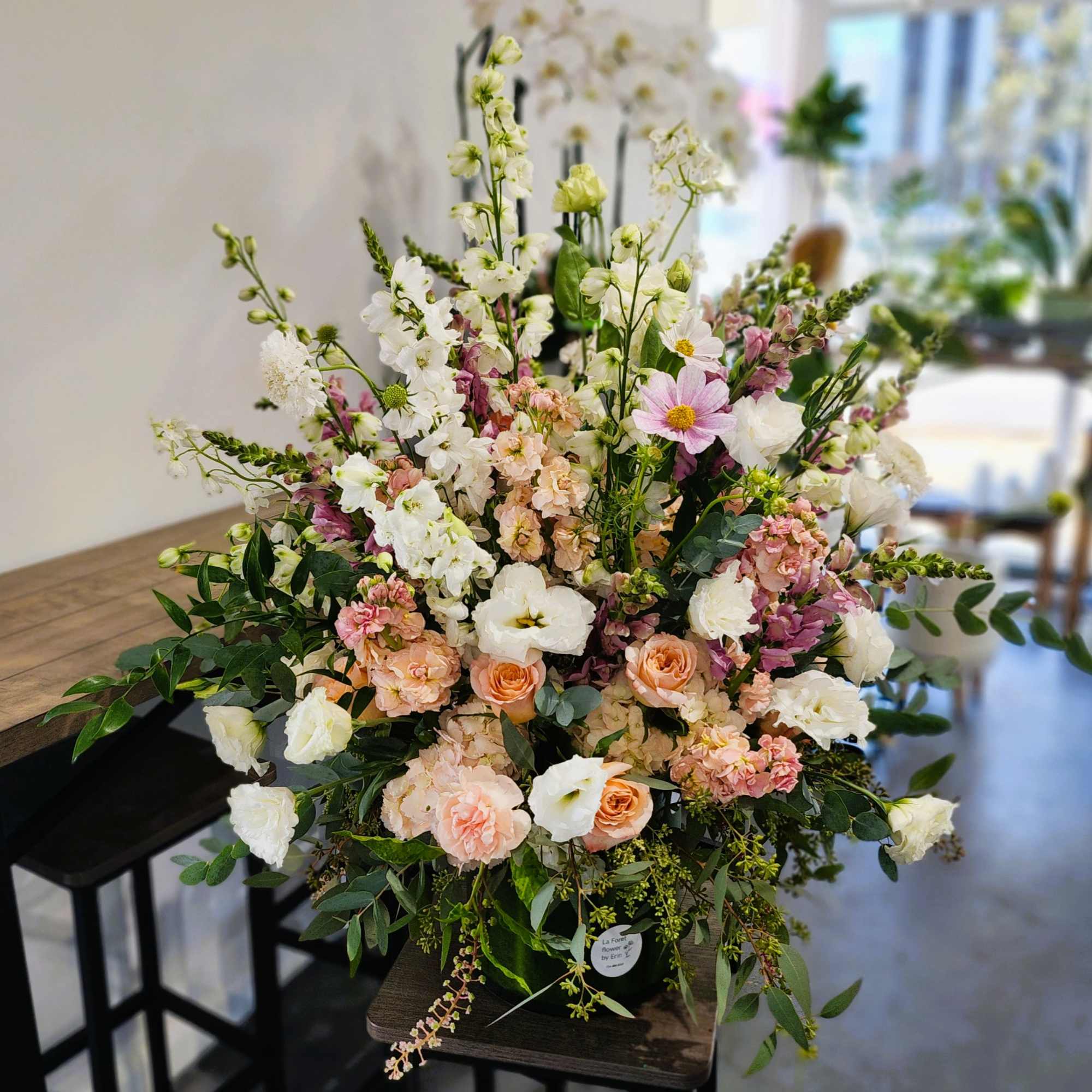 Large pastel flower arrangement with roses, lisianthus, and white blooms