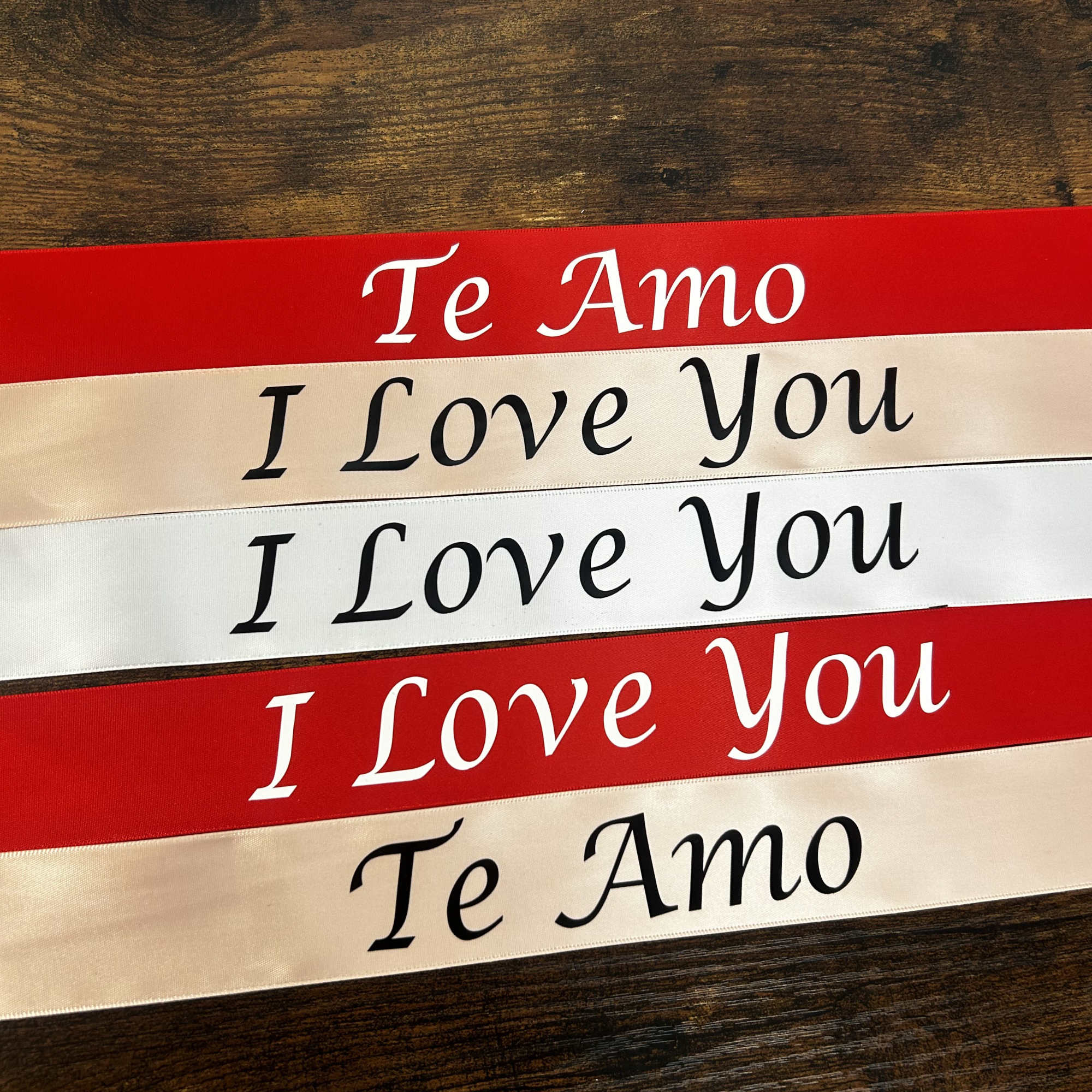 Stacked red and ivory ribbons printed with "Te Amo" and "I Love You"