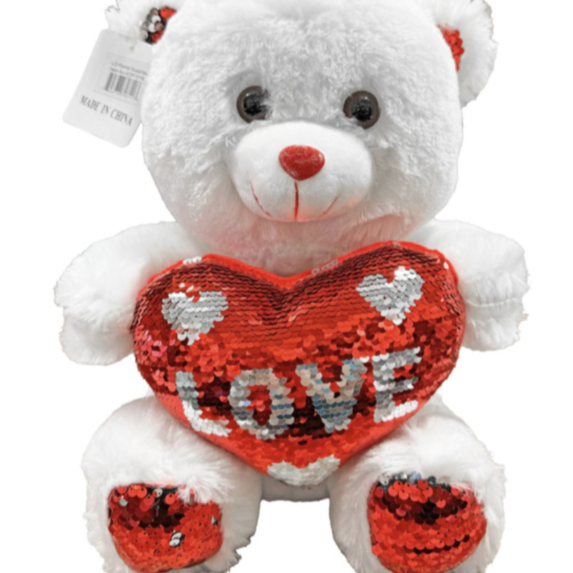 White teddy bear holding a red sequin heart