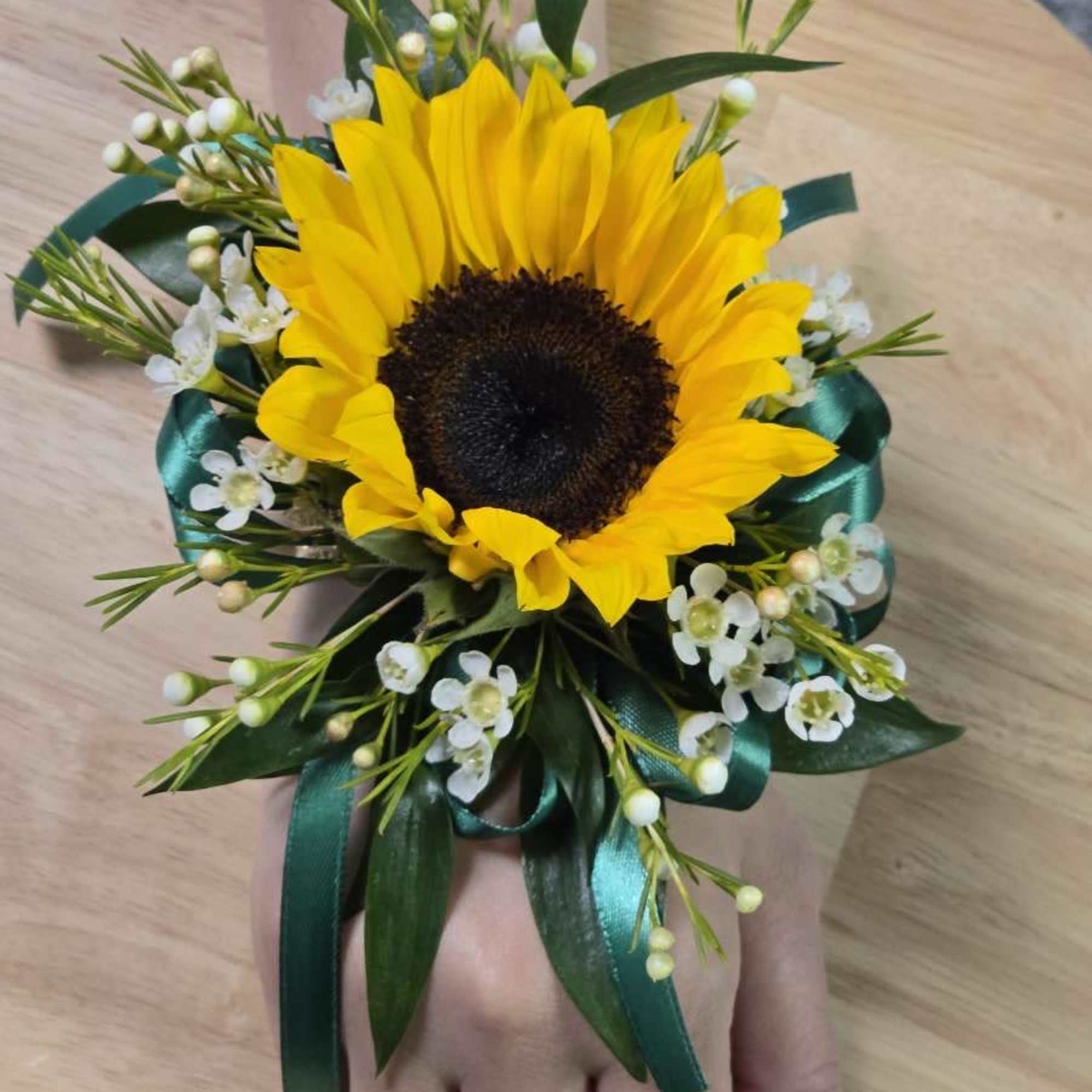Sunflower wrist corsage with white filler flowers and teal ribbon