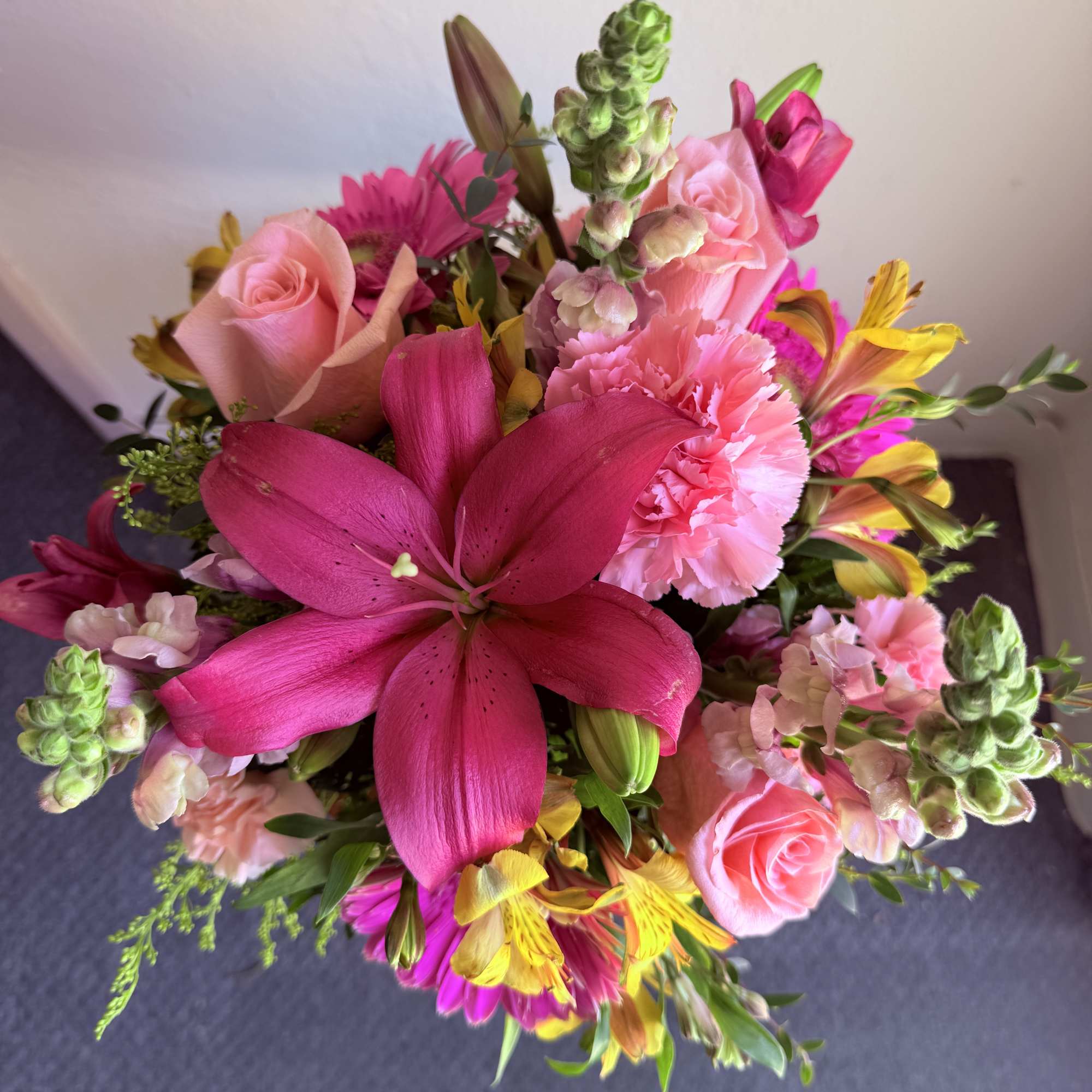 Bright mixed bouquet with pink lilies, roses, carnations, and yellow flowers
