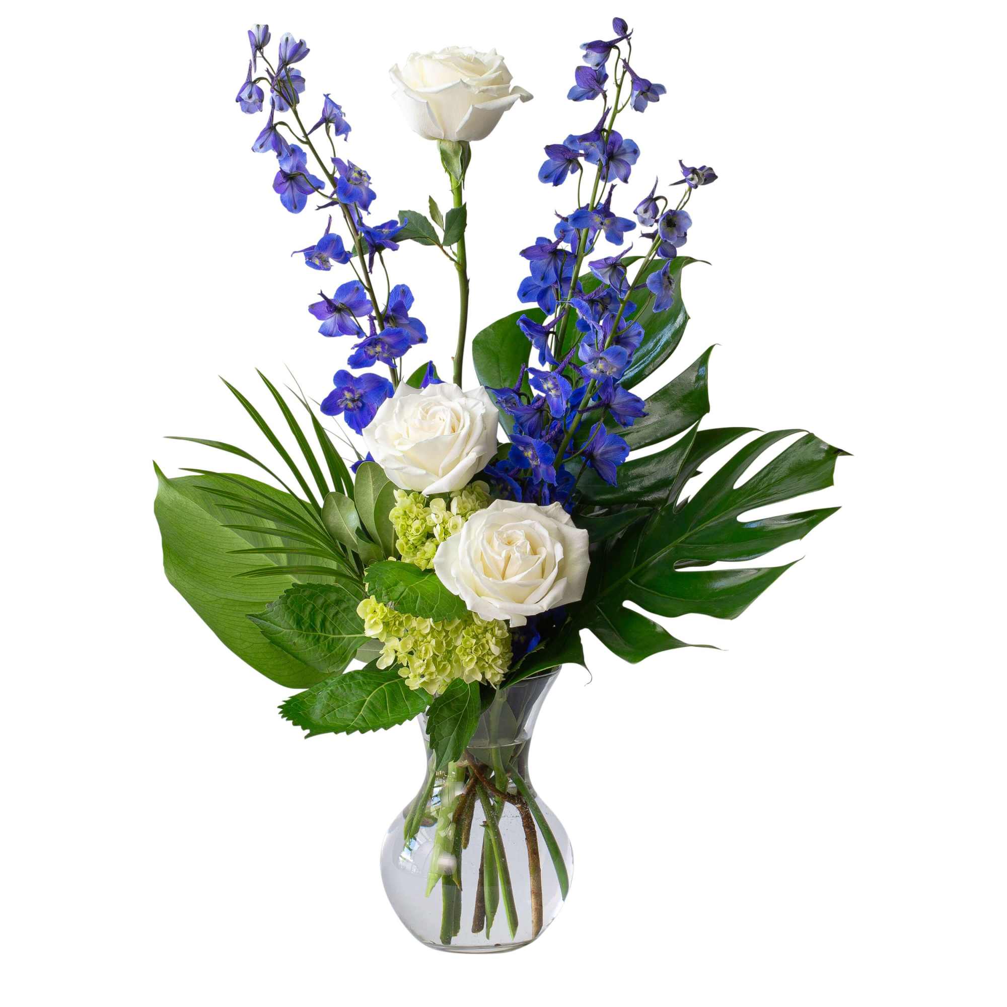 White roses and blue delphinium in a clear glass vase