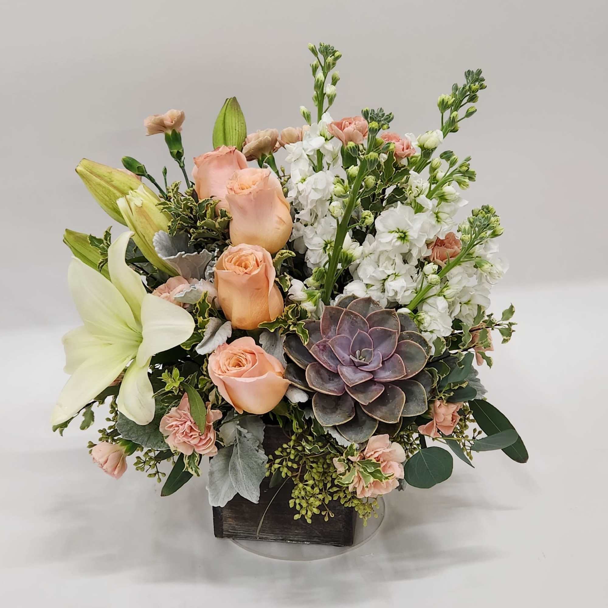 Peaceful yet energizing, this unforgettable arrangement of desert-hued blooms and succulents in