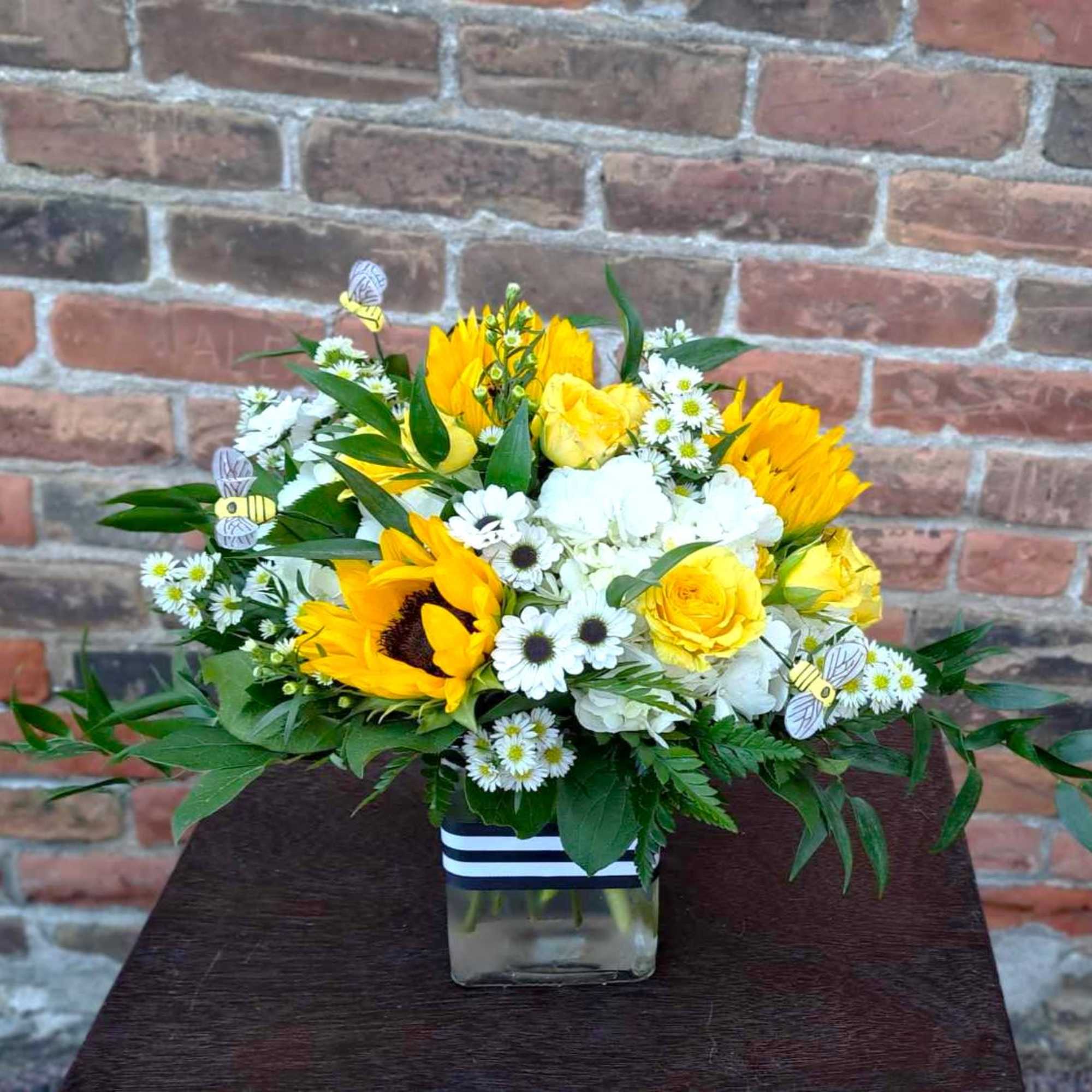 This adorable bouquet is designed in a glass vase with yellow sunflowers