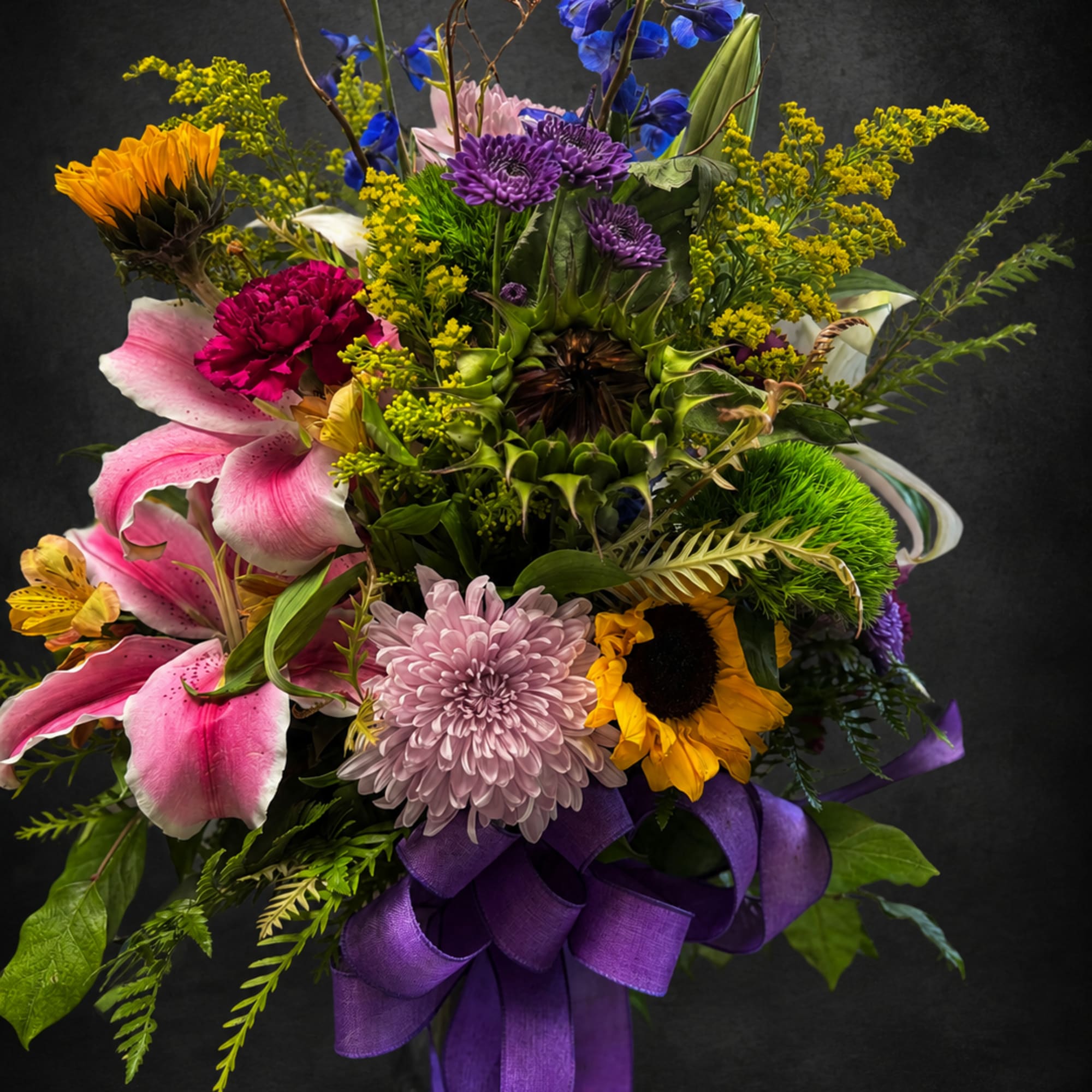 A tall, garden-style mixed bouquet that greets the eye with cheerful sunflowers
