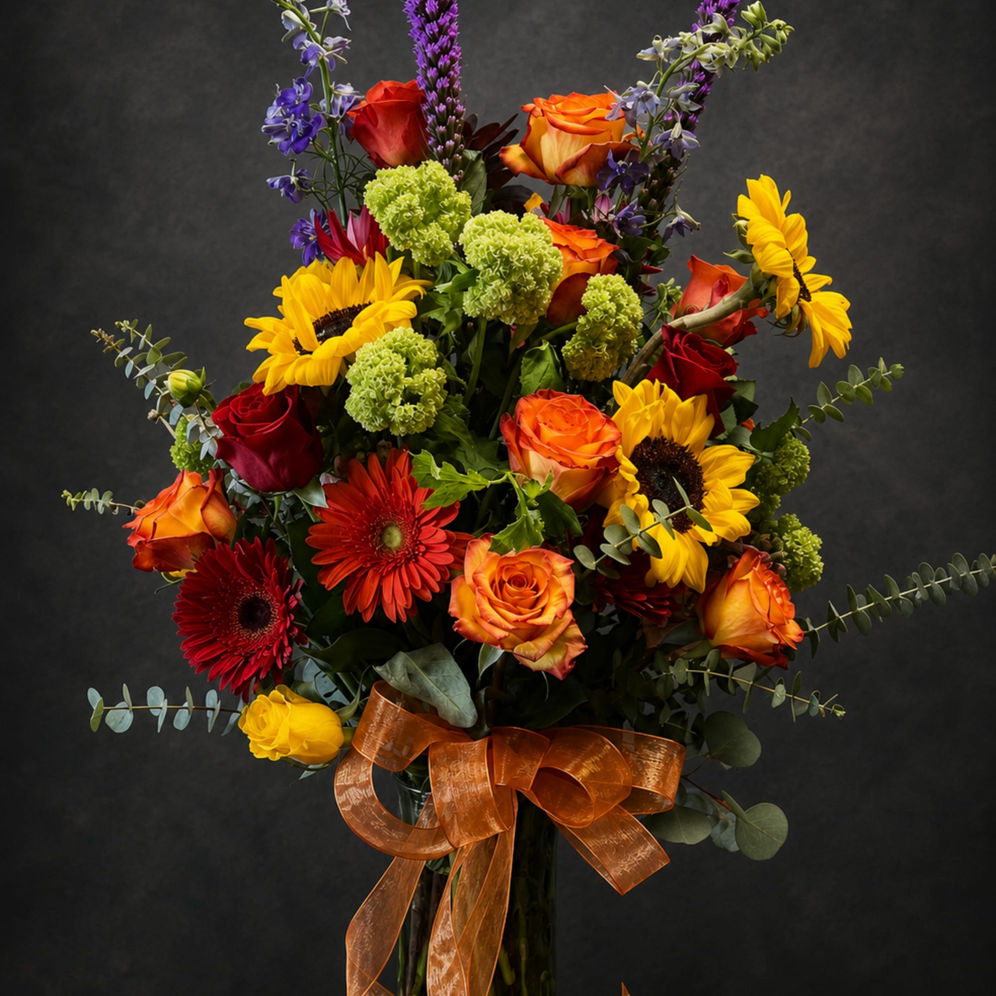 Bold, sunlit color greets the recipient with this tall mixed flower arrangement-perfect