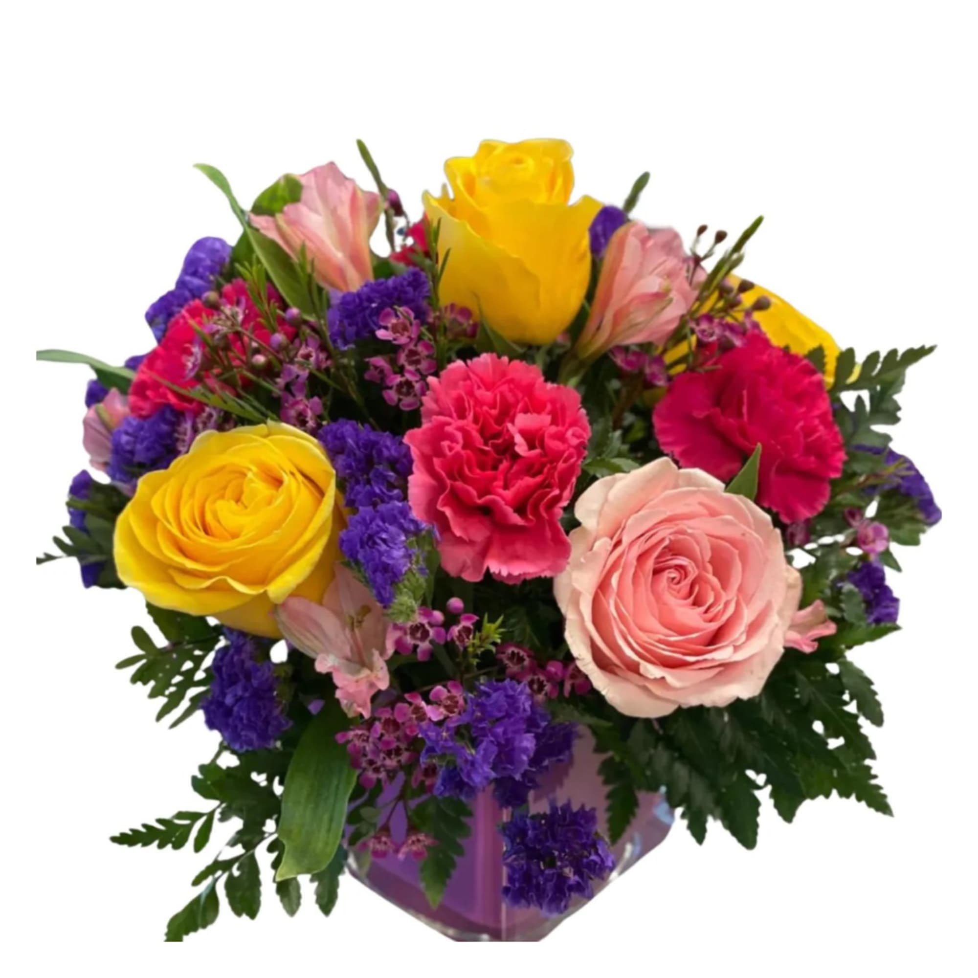 Mixed bouquet of roses, carnations, and purple filler flowers in a clear vase