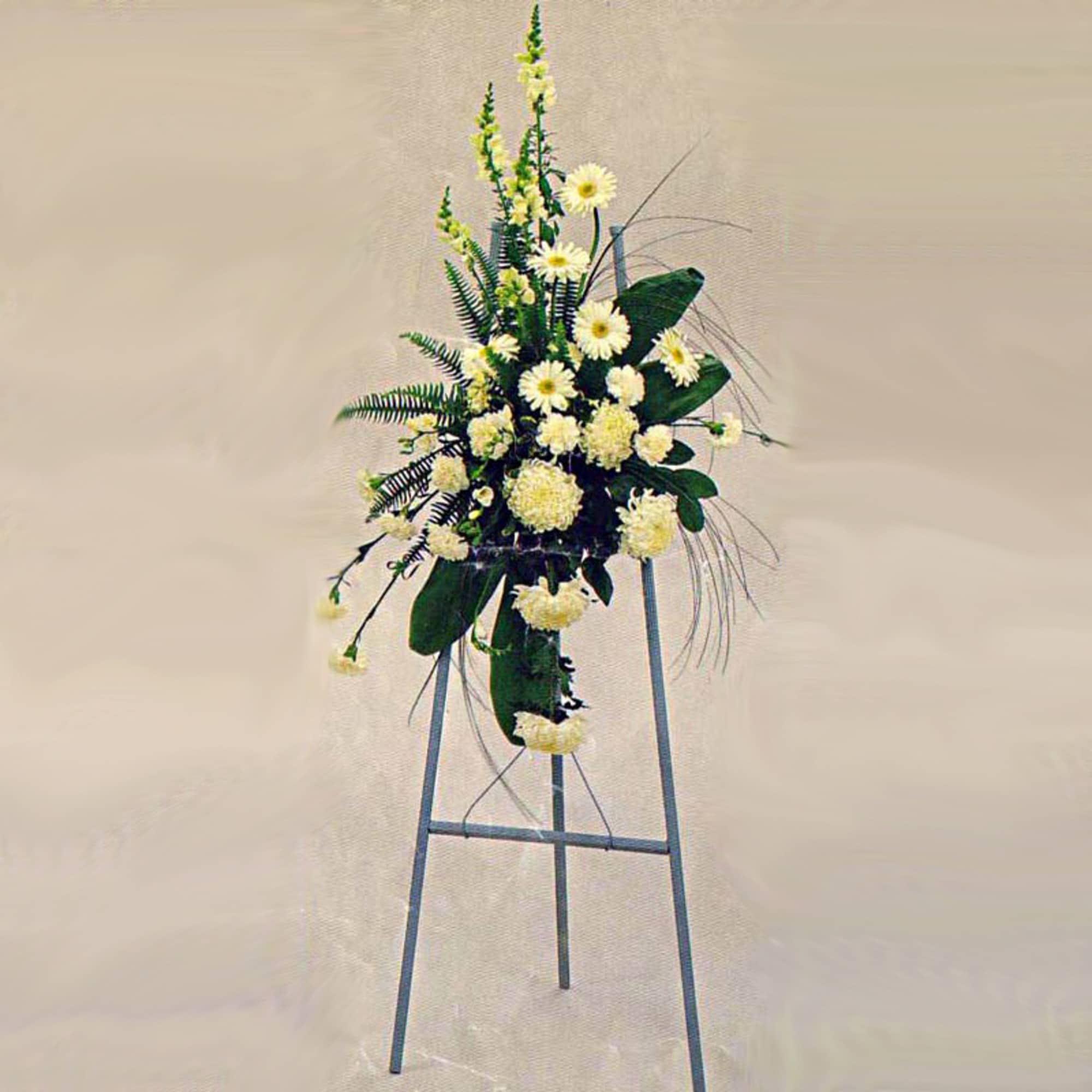 Tall white floral standing spray on a metal easel