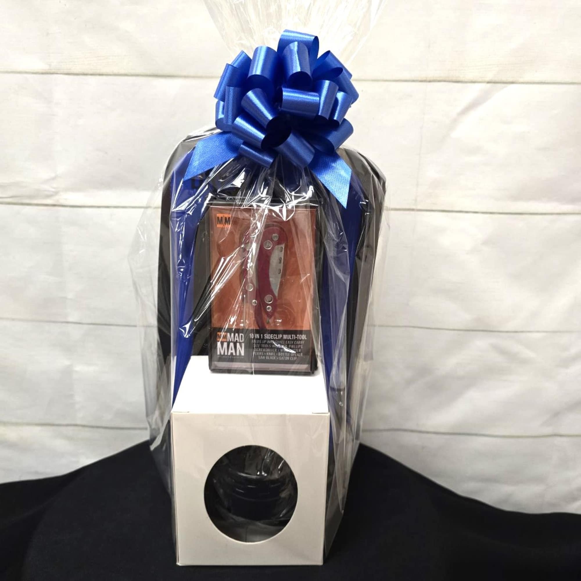 Gift set with boxed multi-tool and glass in a white box wrapped in cellophane with a blue bow