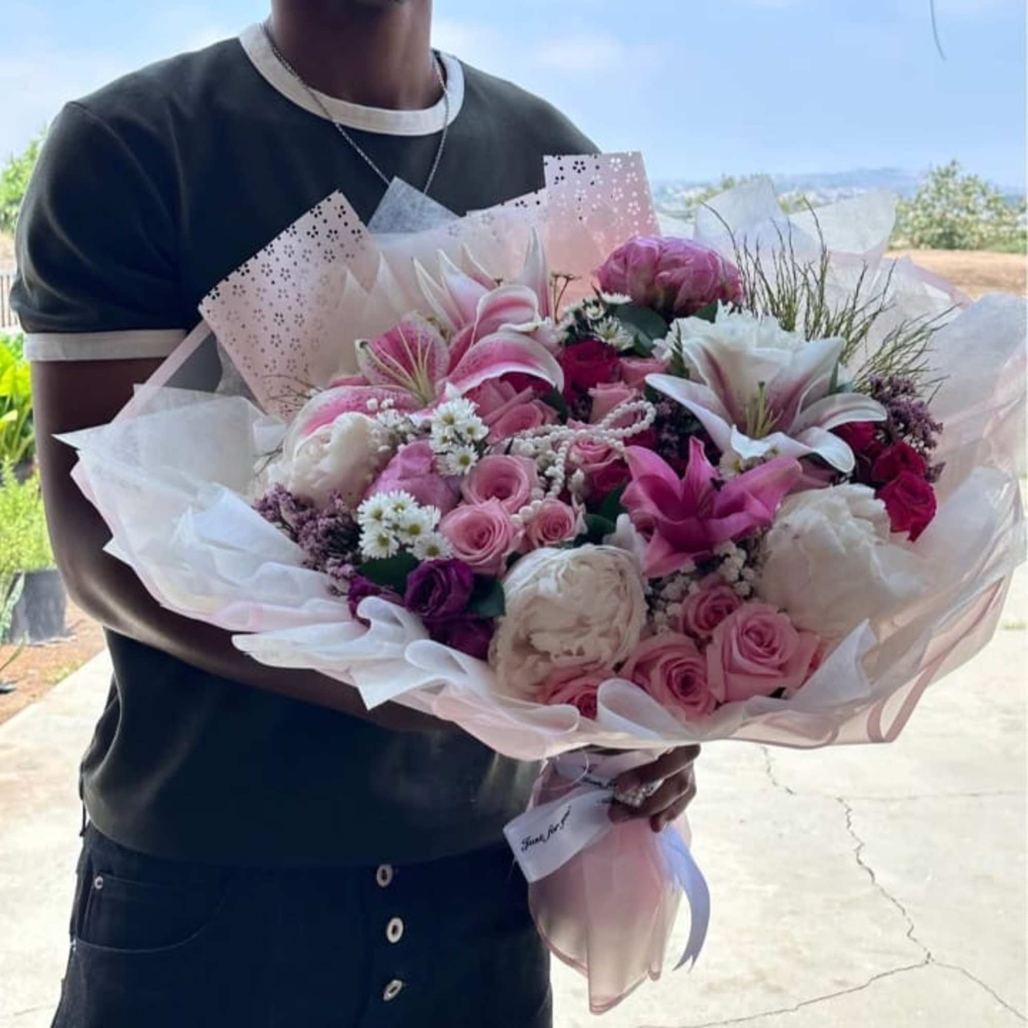 Large pink and white bouquet with roses and lilies wrapped in paper