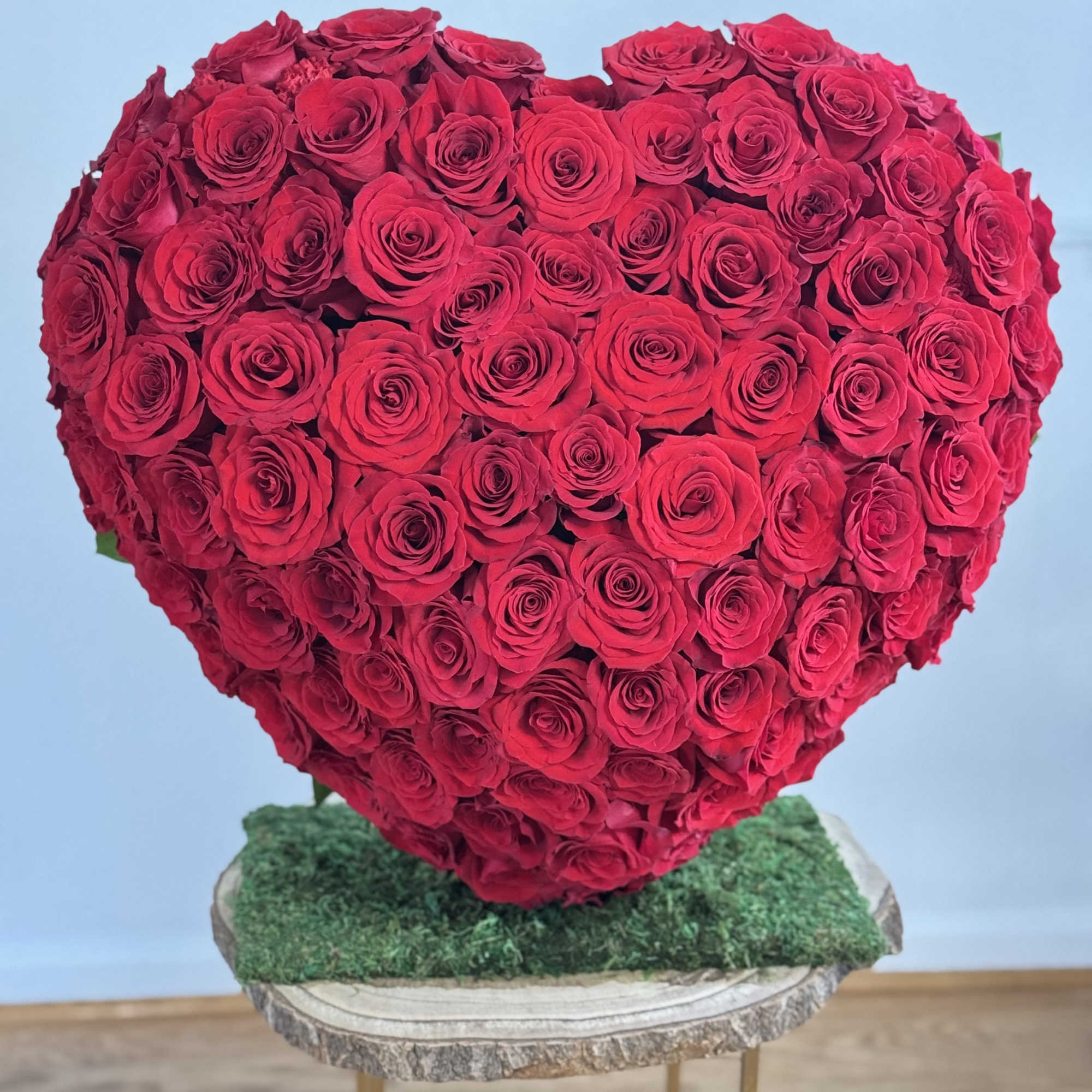 Heart-shaped arrangement of red roses on a stand