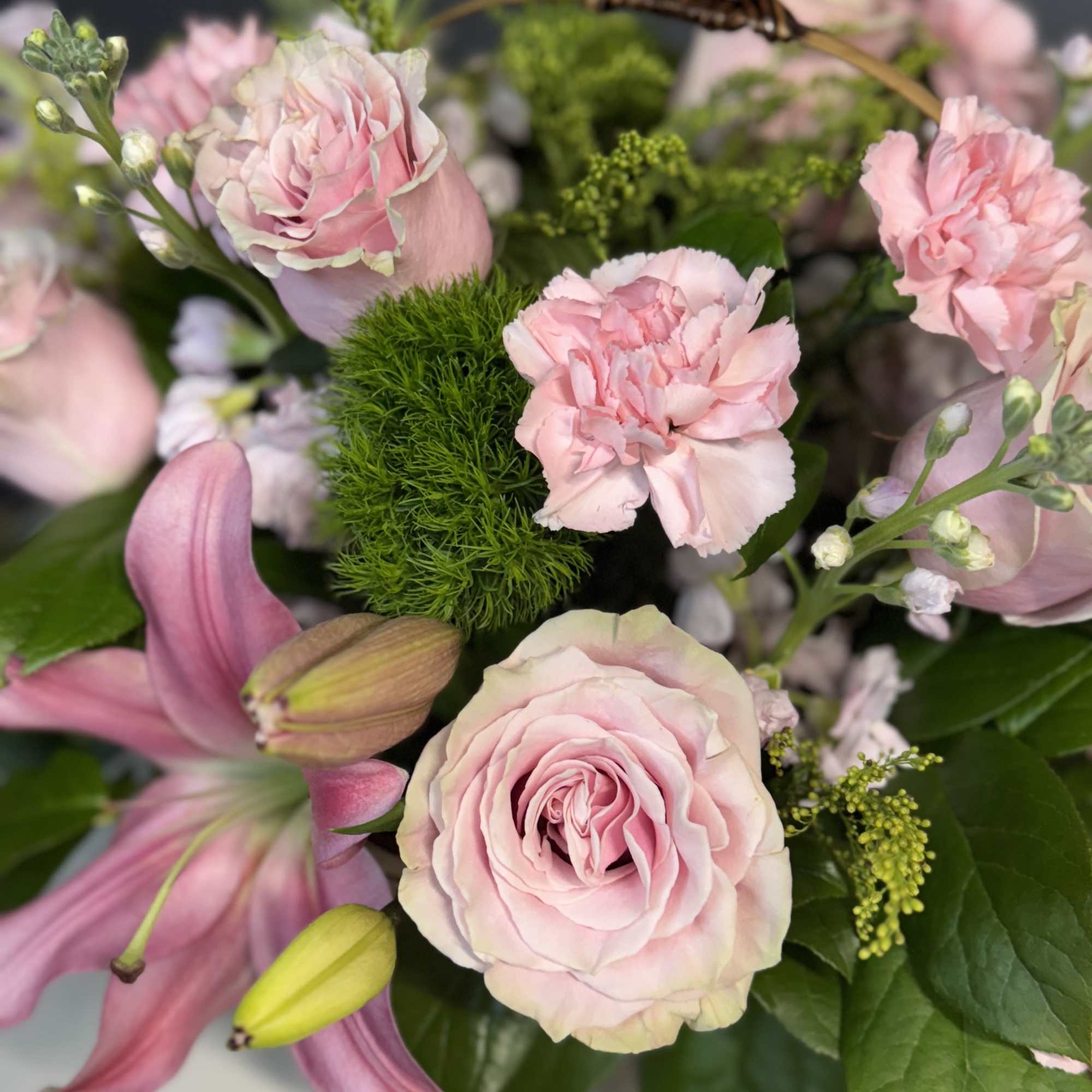 Pink roses and carnations with lilies in a mixed bouquet