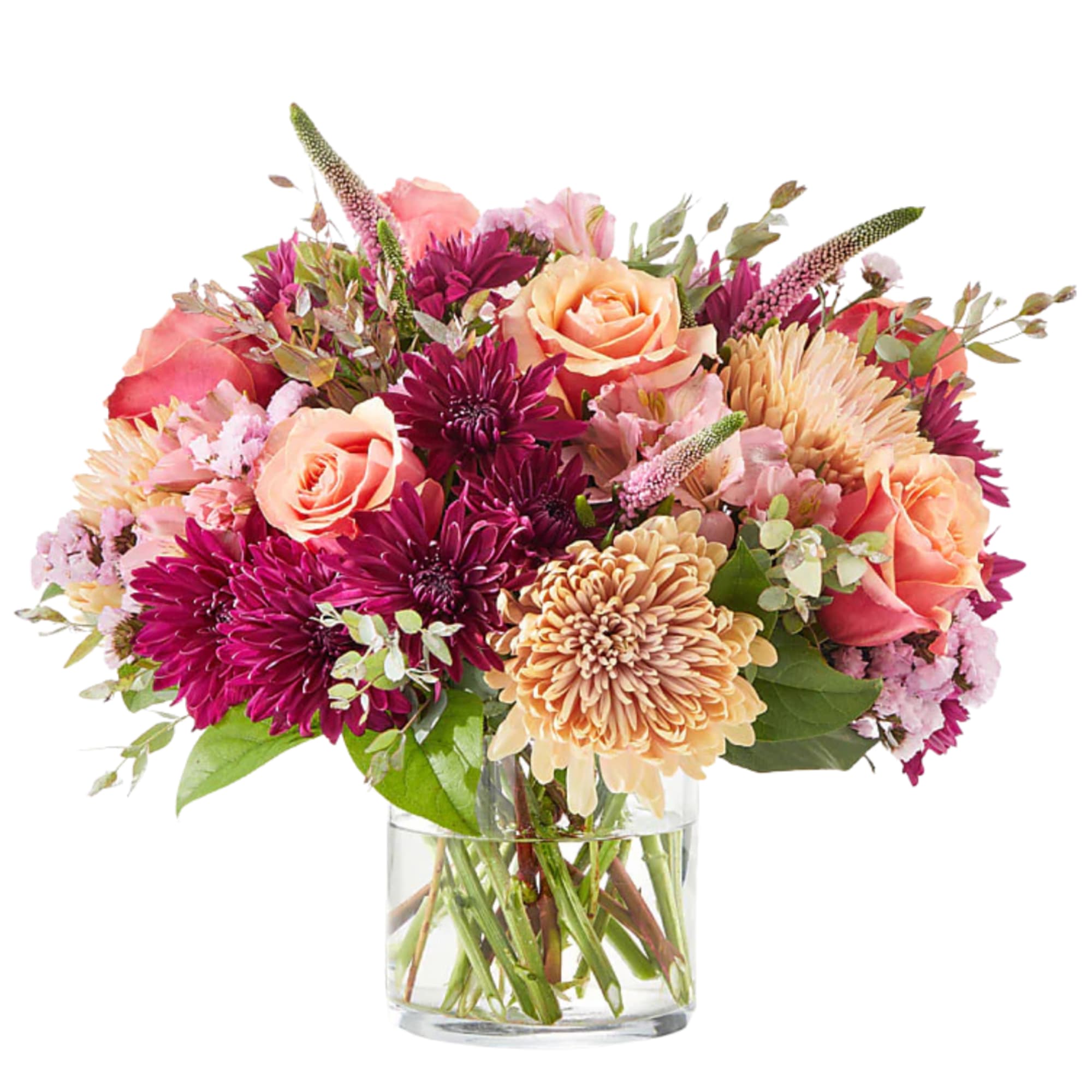 Mixed bouquet of pink, peach, and purple flowers in a clear glass vase