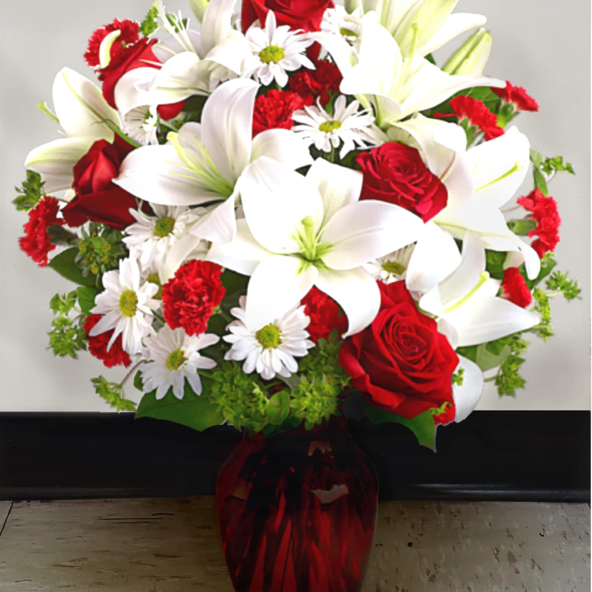 Bouquet of red roses, white lilies, and white daisies in a red vase