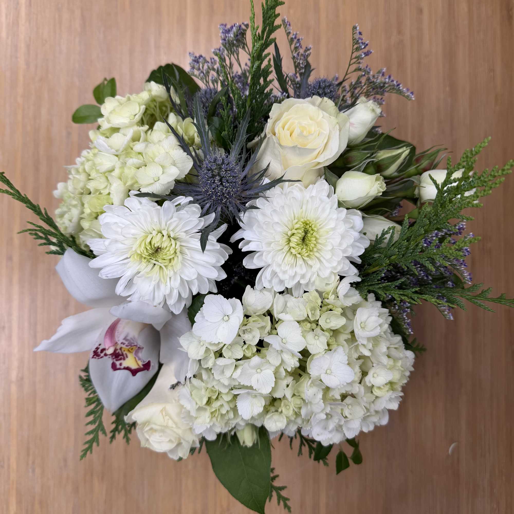 White bouquet with roses, hydrangeas, and daisy-like blooms