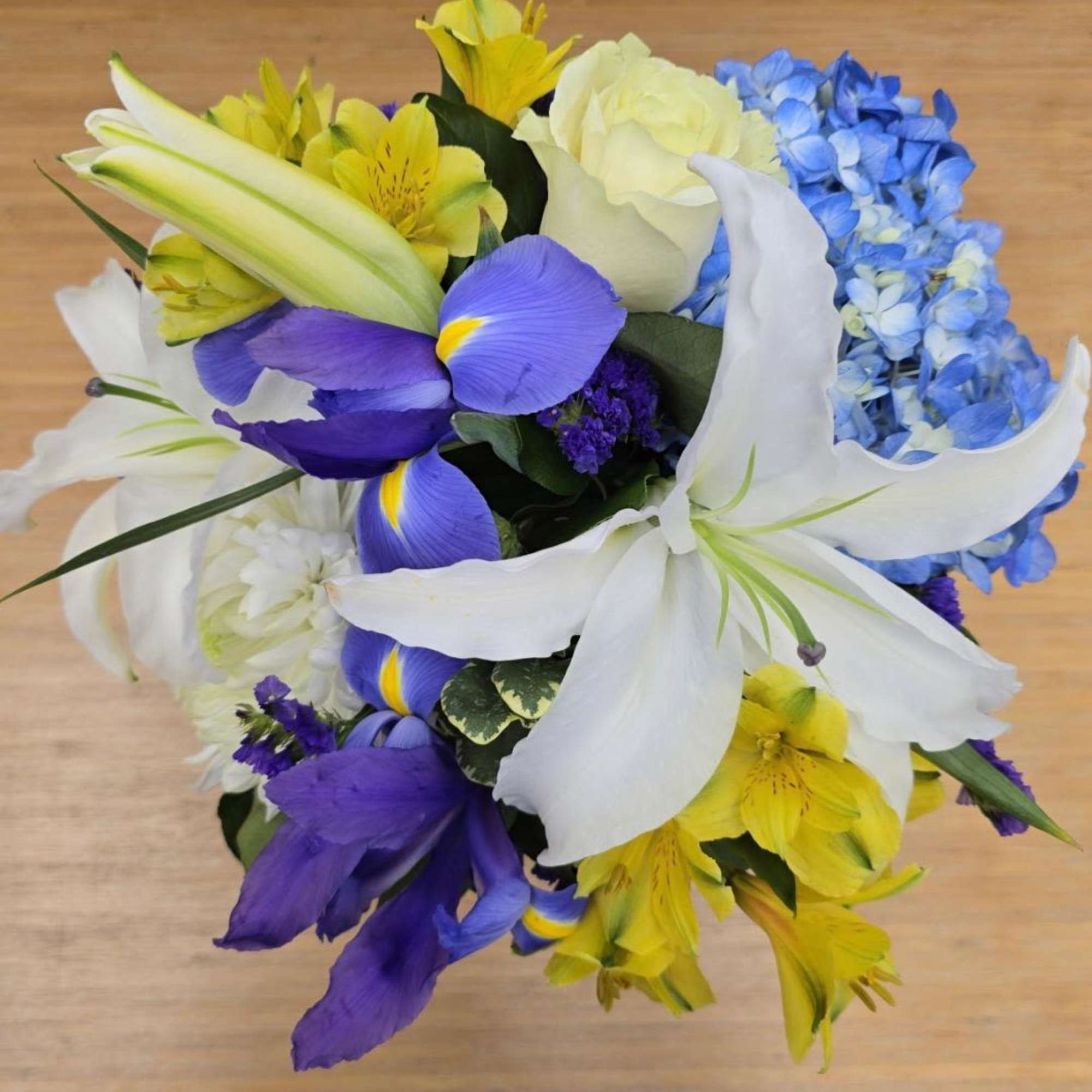 Bouquet of white lilies, blue hydrangea, yellow alstroemeria, and purple irises