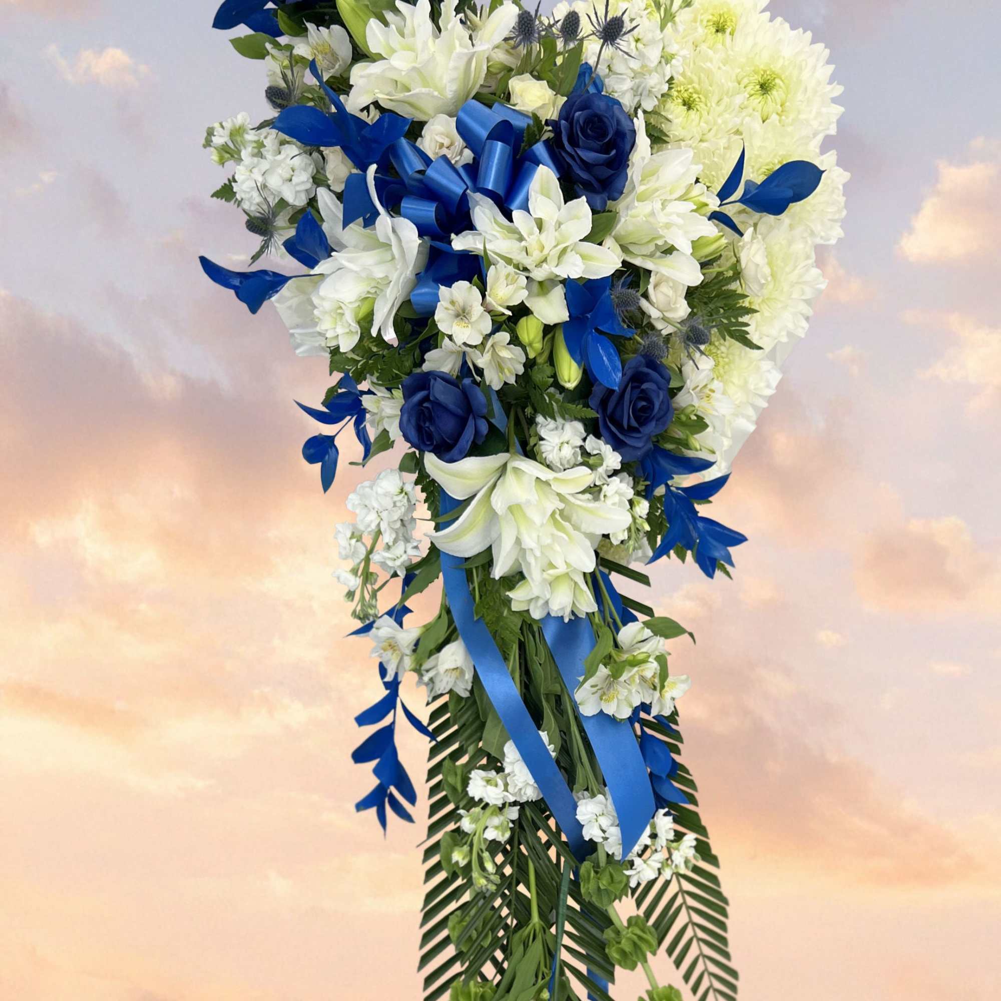 Tall floral spray with white and blue flowers and ribbon