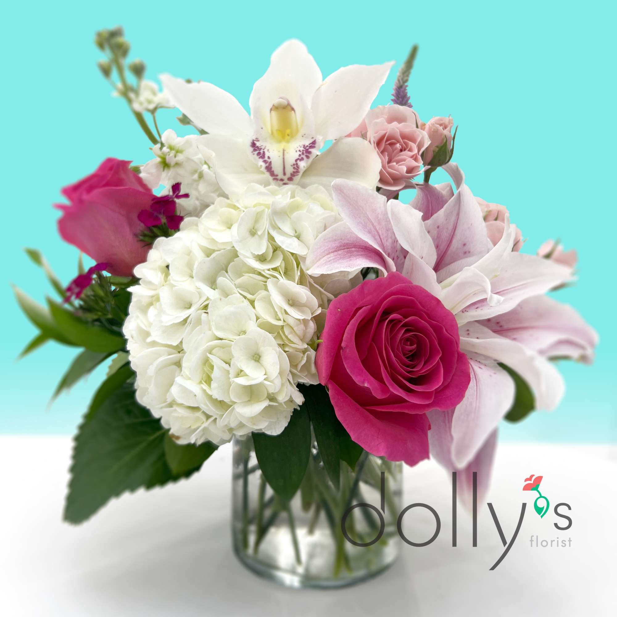 Bright pink roses and pale pink lilies take center stage in this, photo 2 of 3