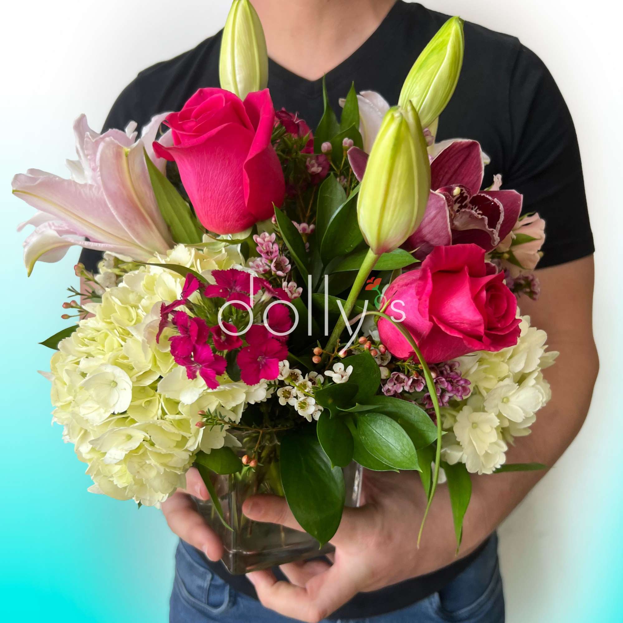 Bouquet of pink roses, lilies, and hydrangeas in a glass vase