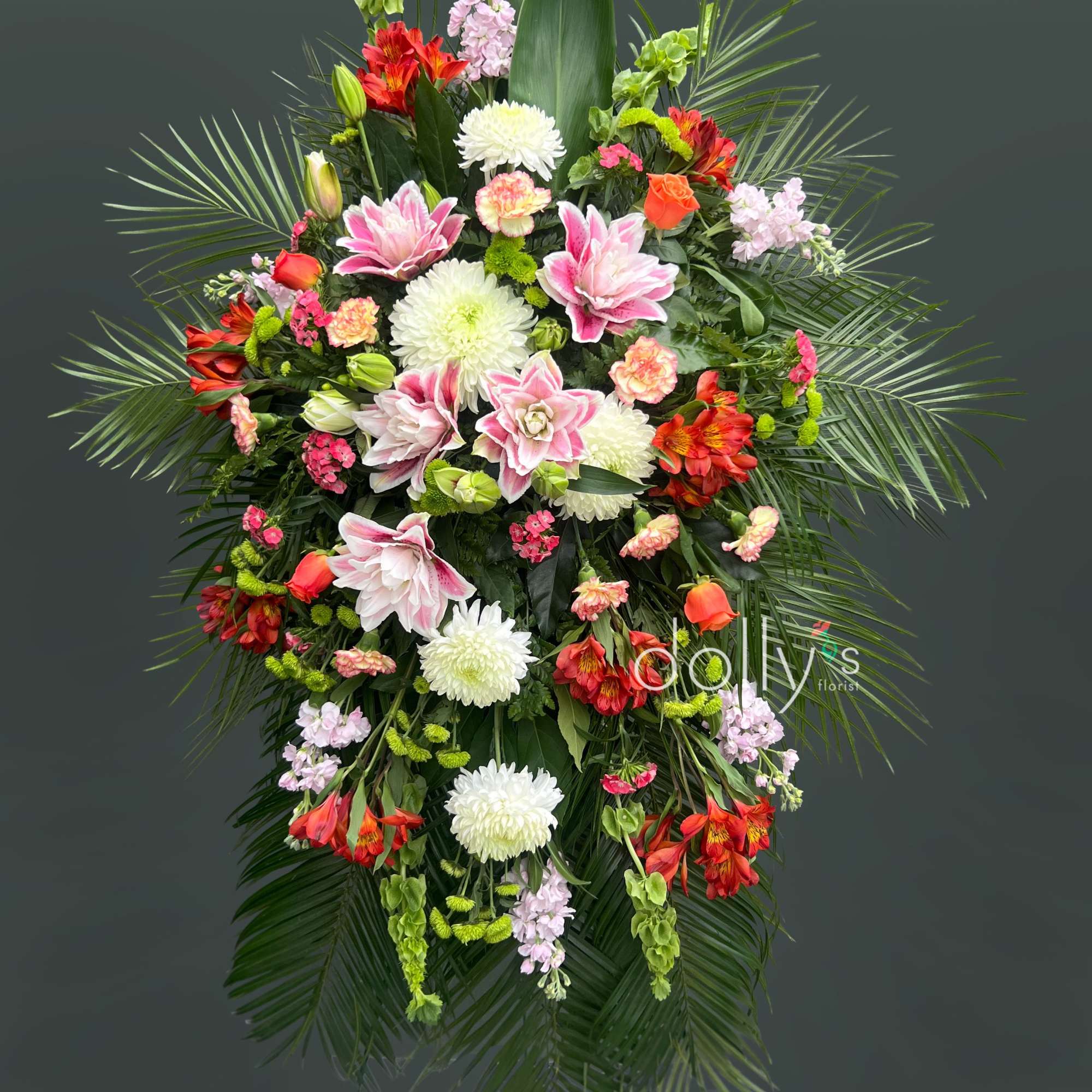 A tall, formal standing spray that greets the room with quiet warmth-perfect