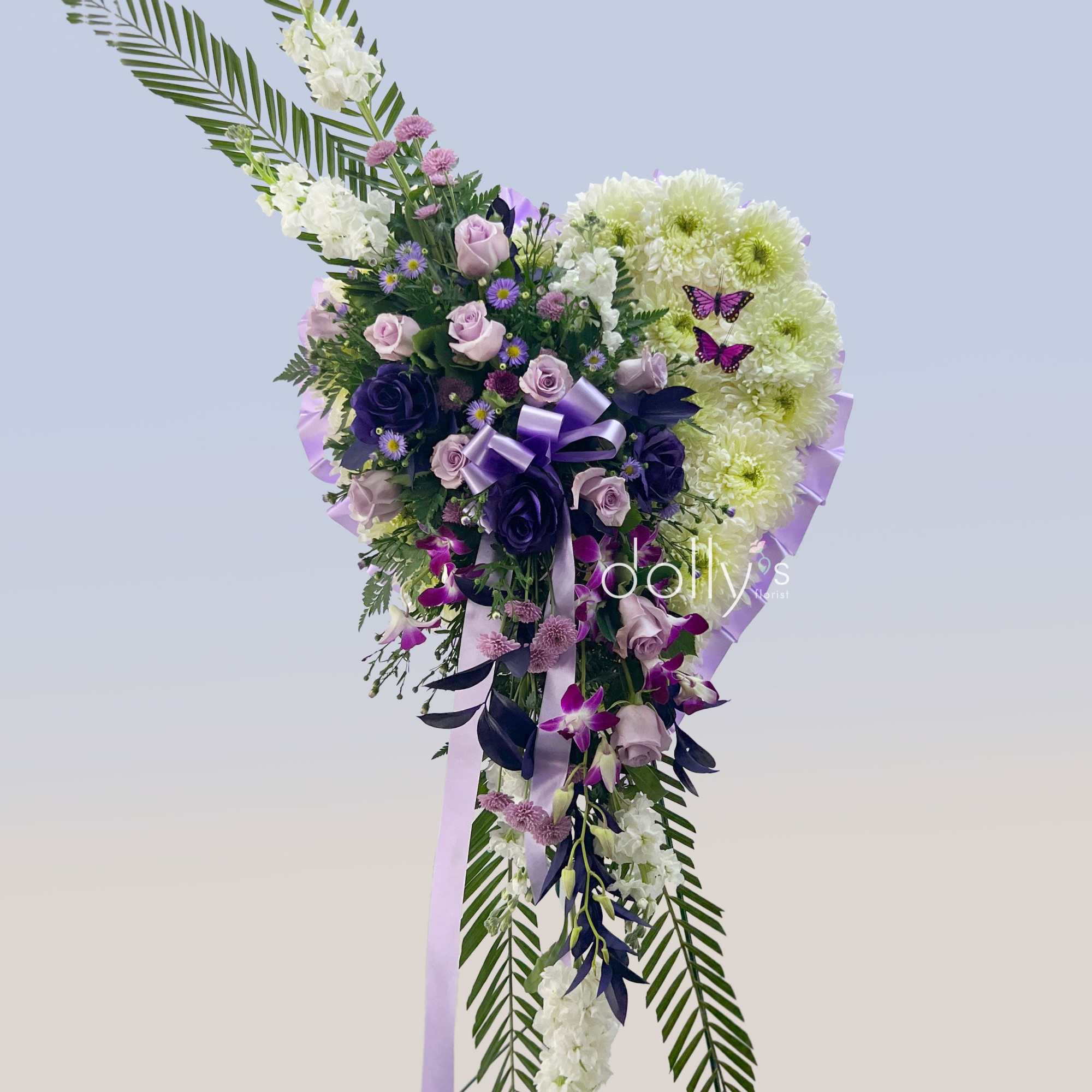 A tall, cascading floral spray in soft purples and whites makes a