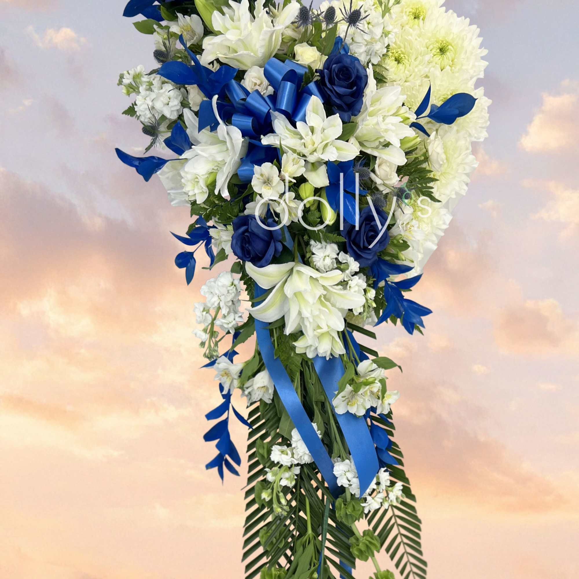 A tall, cascading sympathy spray that reads with ceremonial grace: white lilies