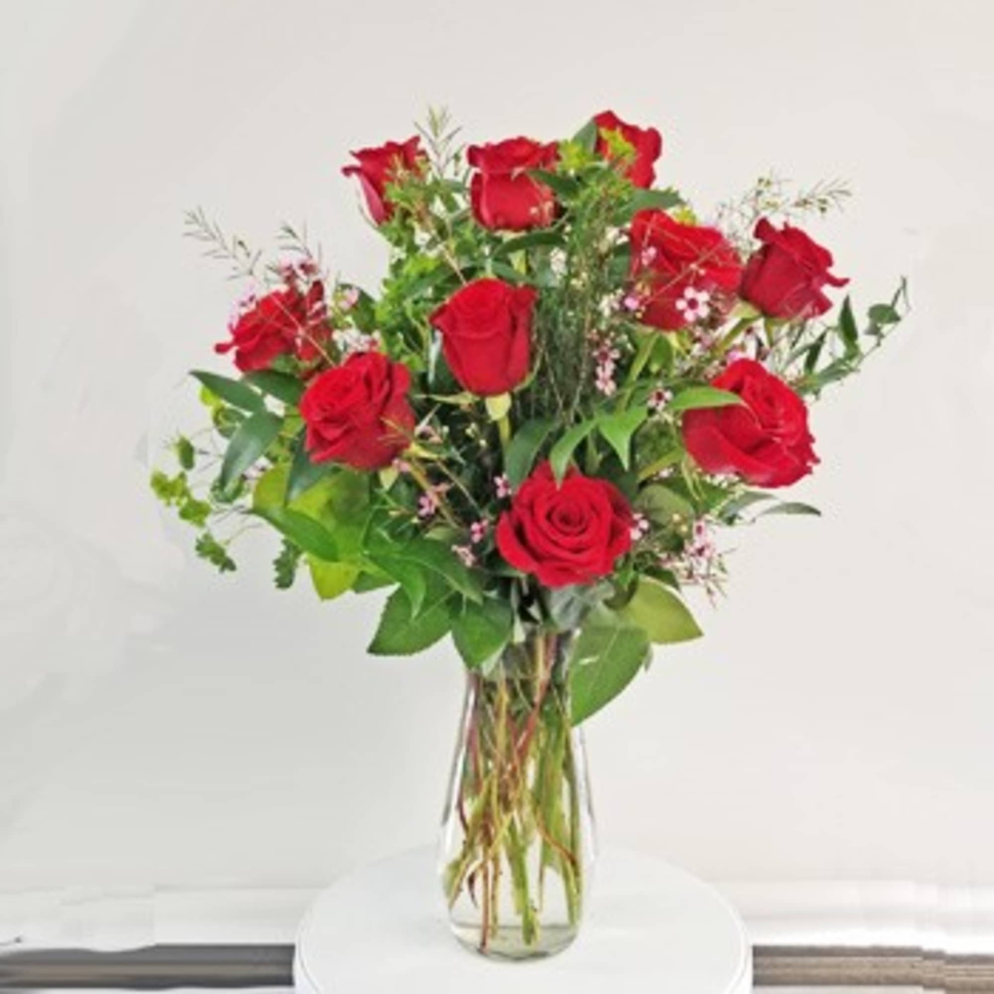 Red roses arranged in a clear glass vase