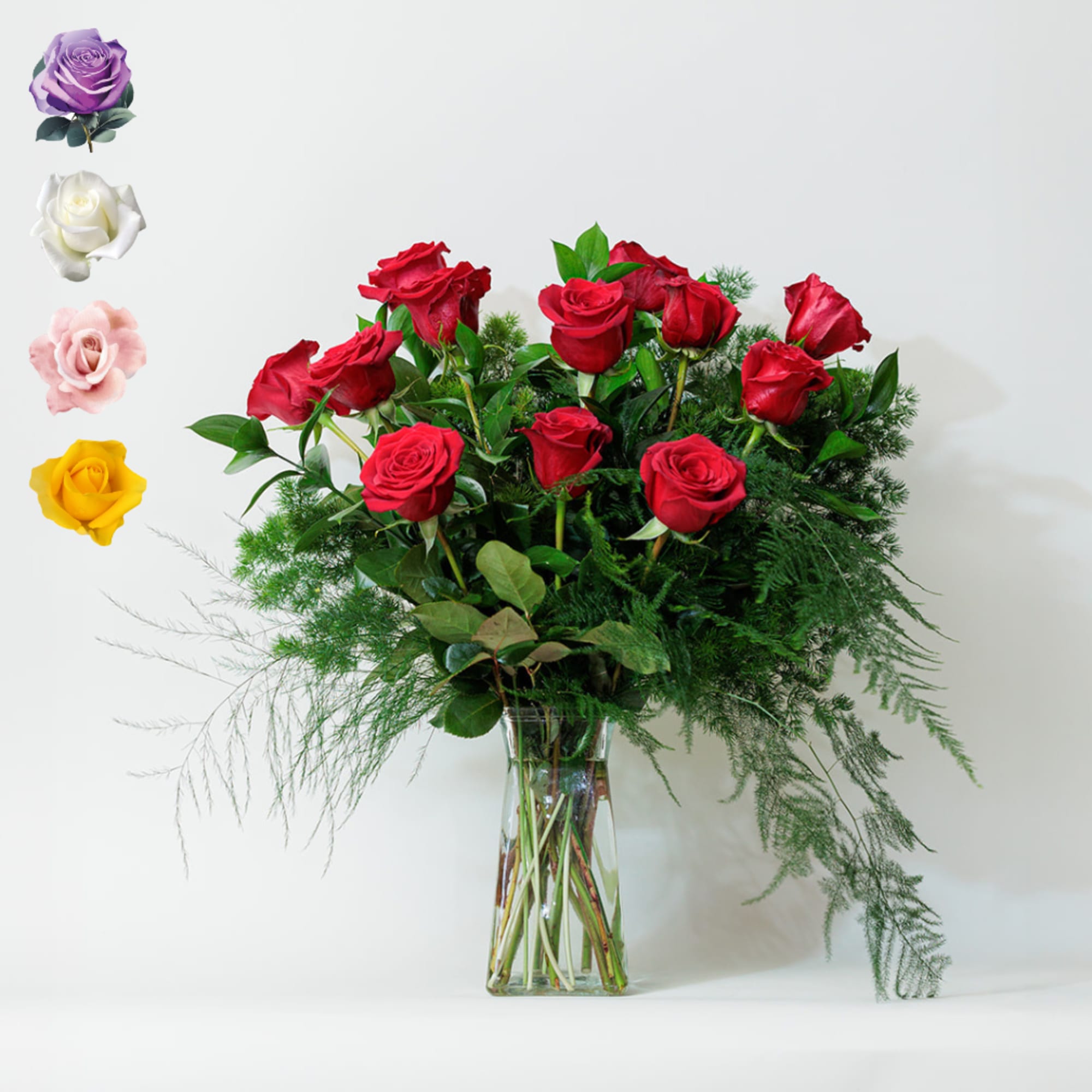 Red roses arranged in a clear glass vase with airy greenery