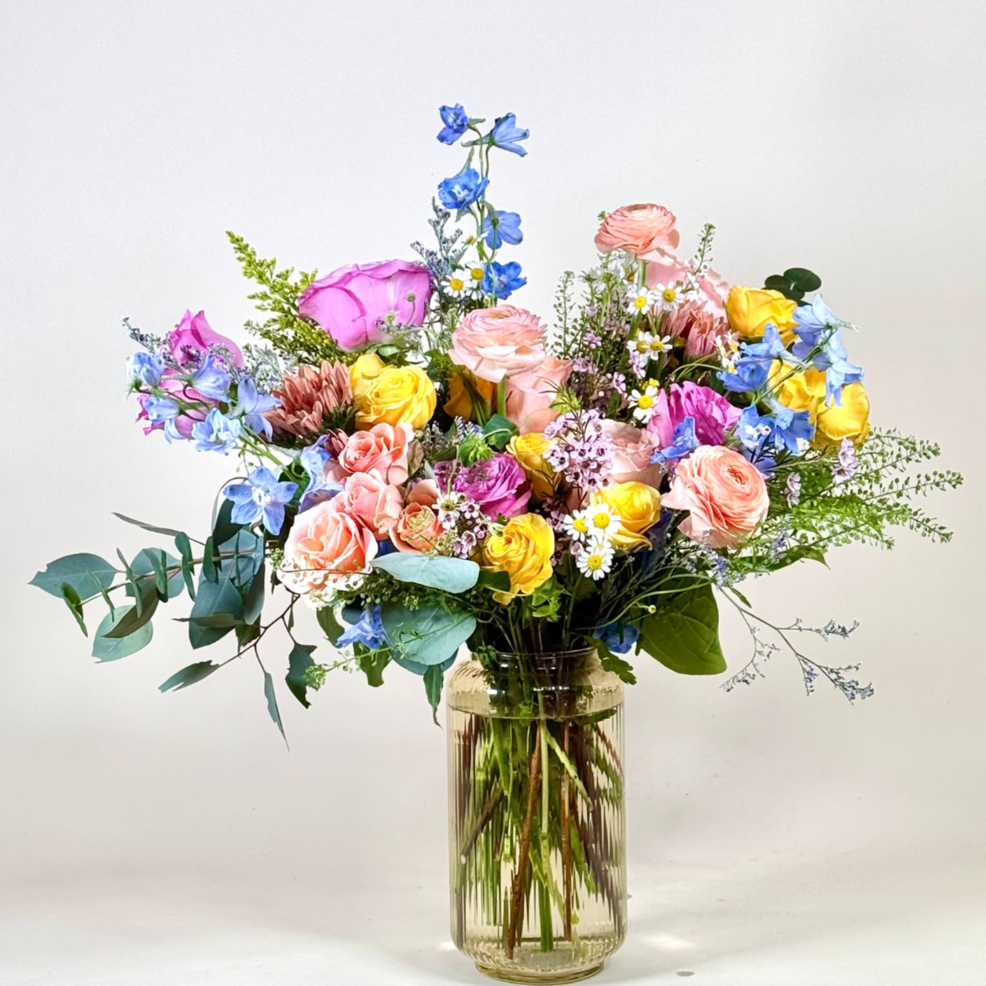 Celebrate the beauty of spring with this cheerful and vibrant floral arrangement