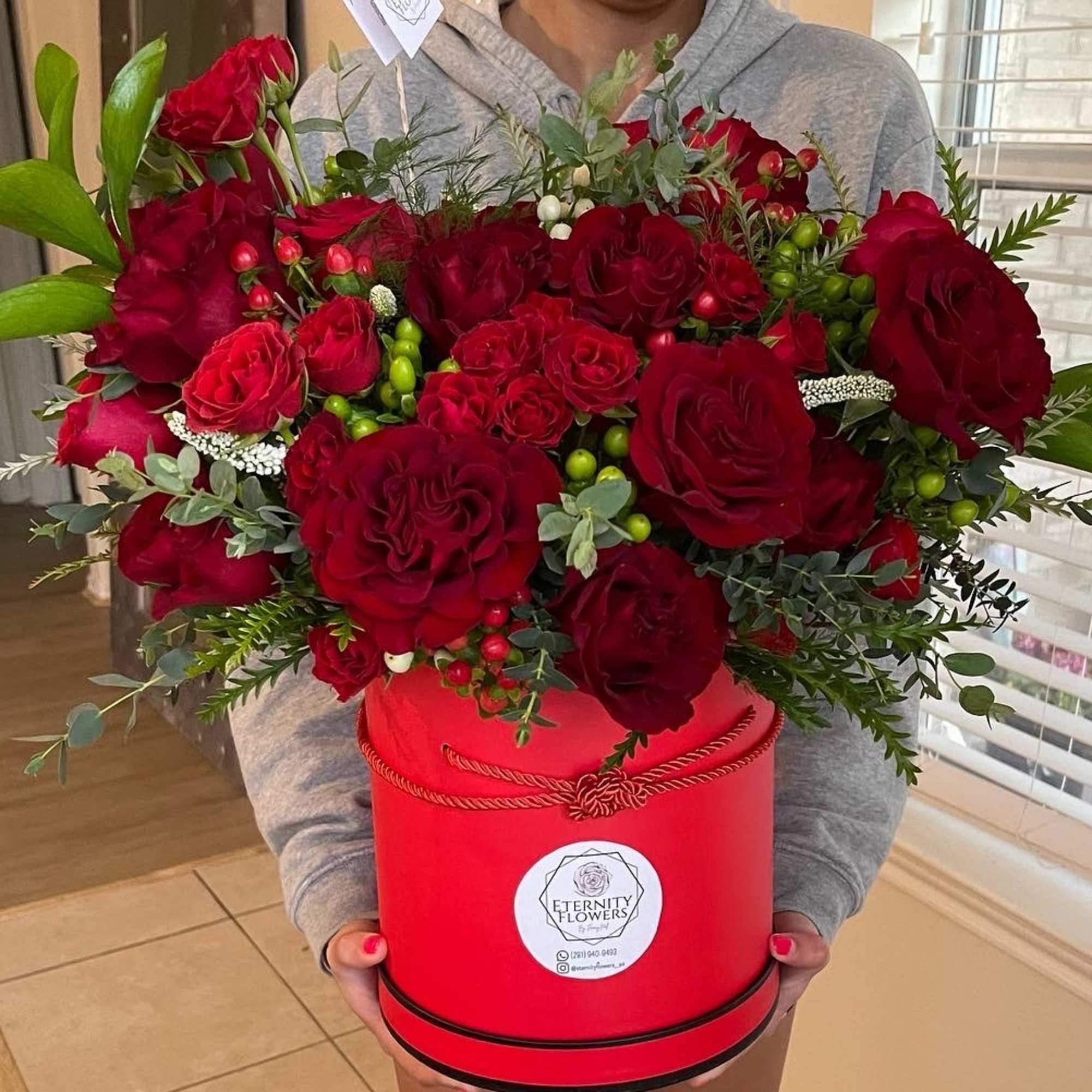 Large red rose bouquet in a red hatbox