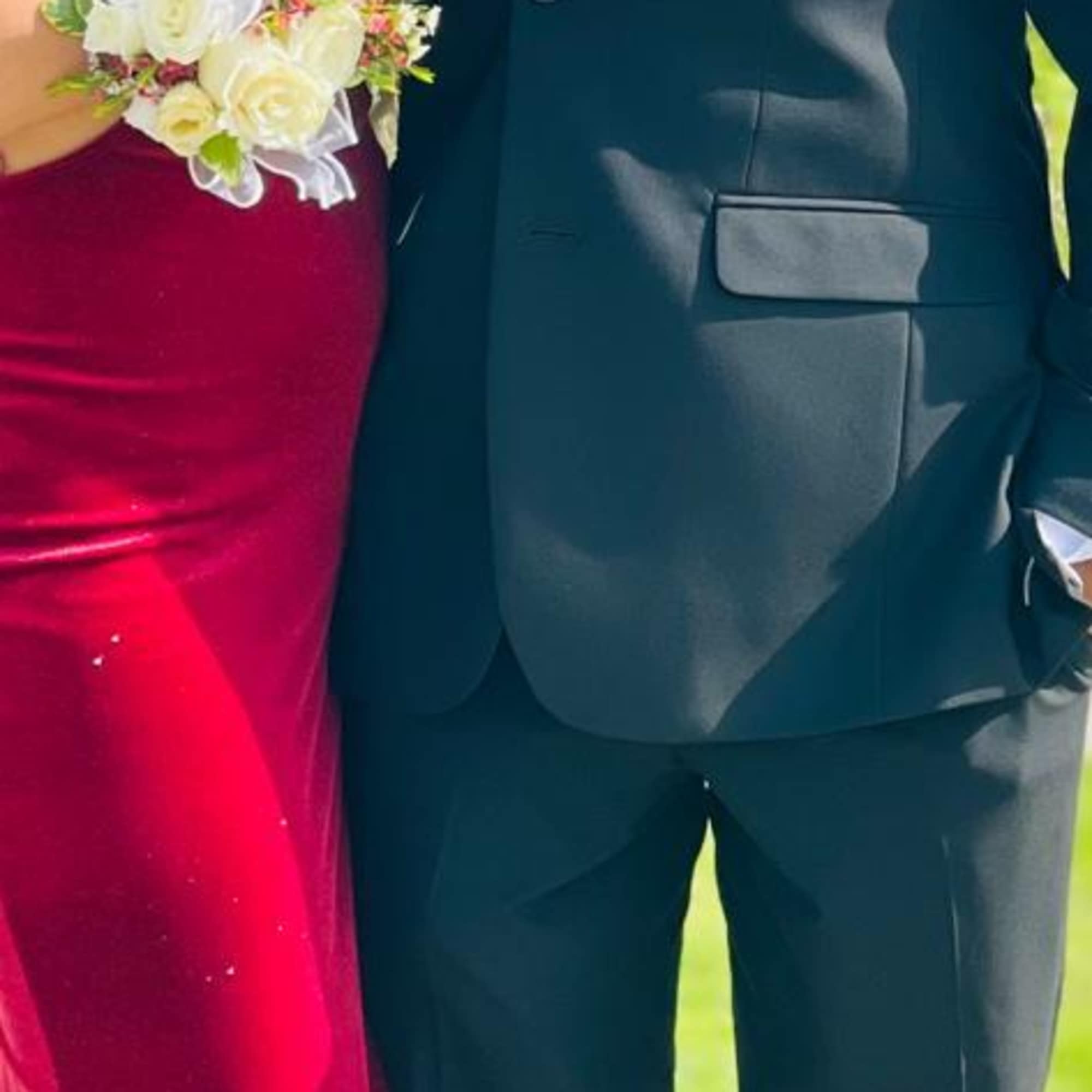 Bride and groom wearing floral wrist corsages and boutonniere