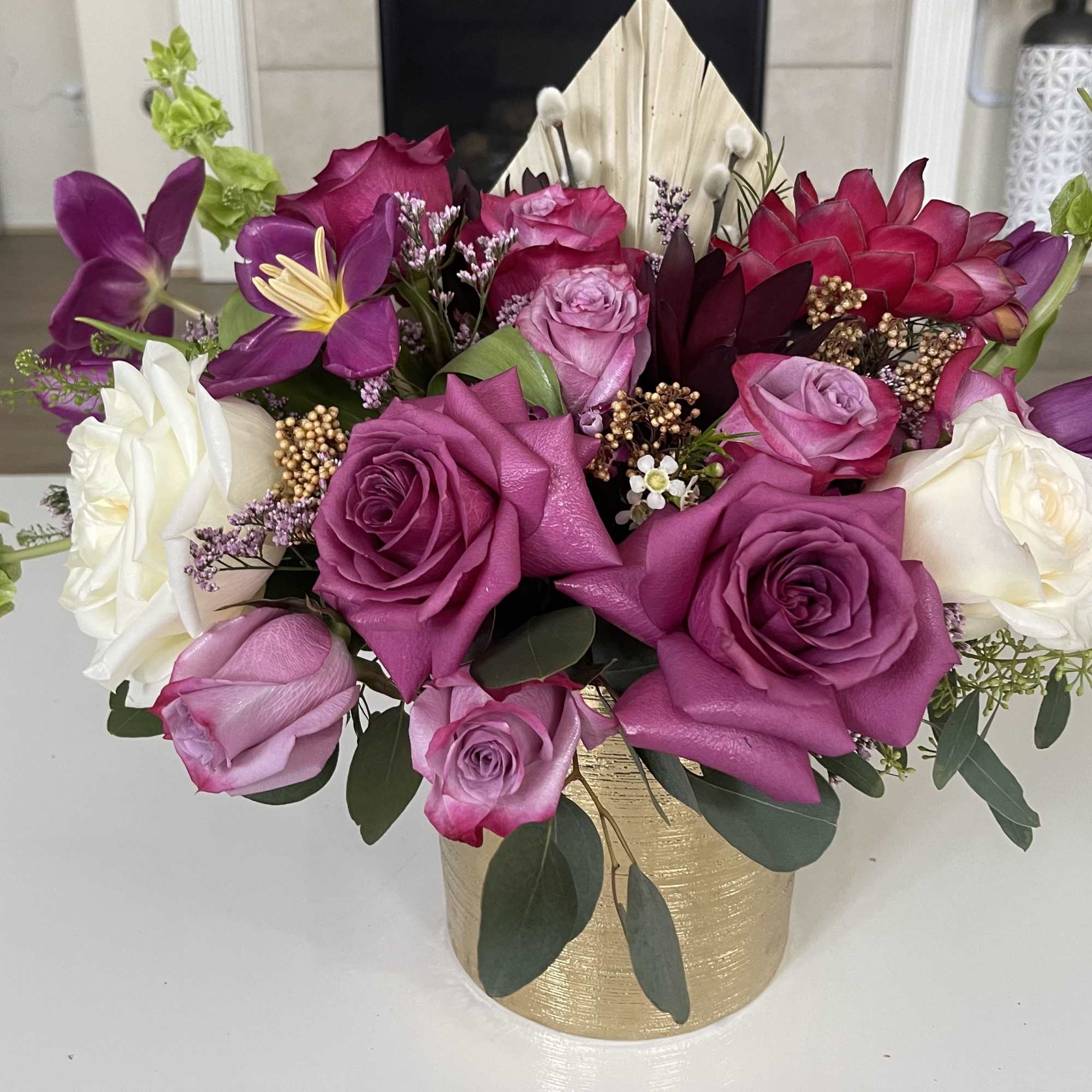 Pink and white roses arranged in a gold vase
