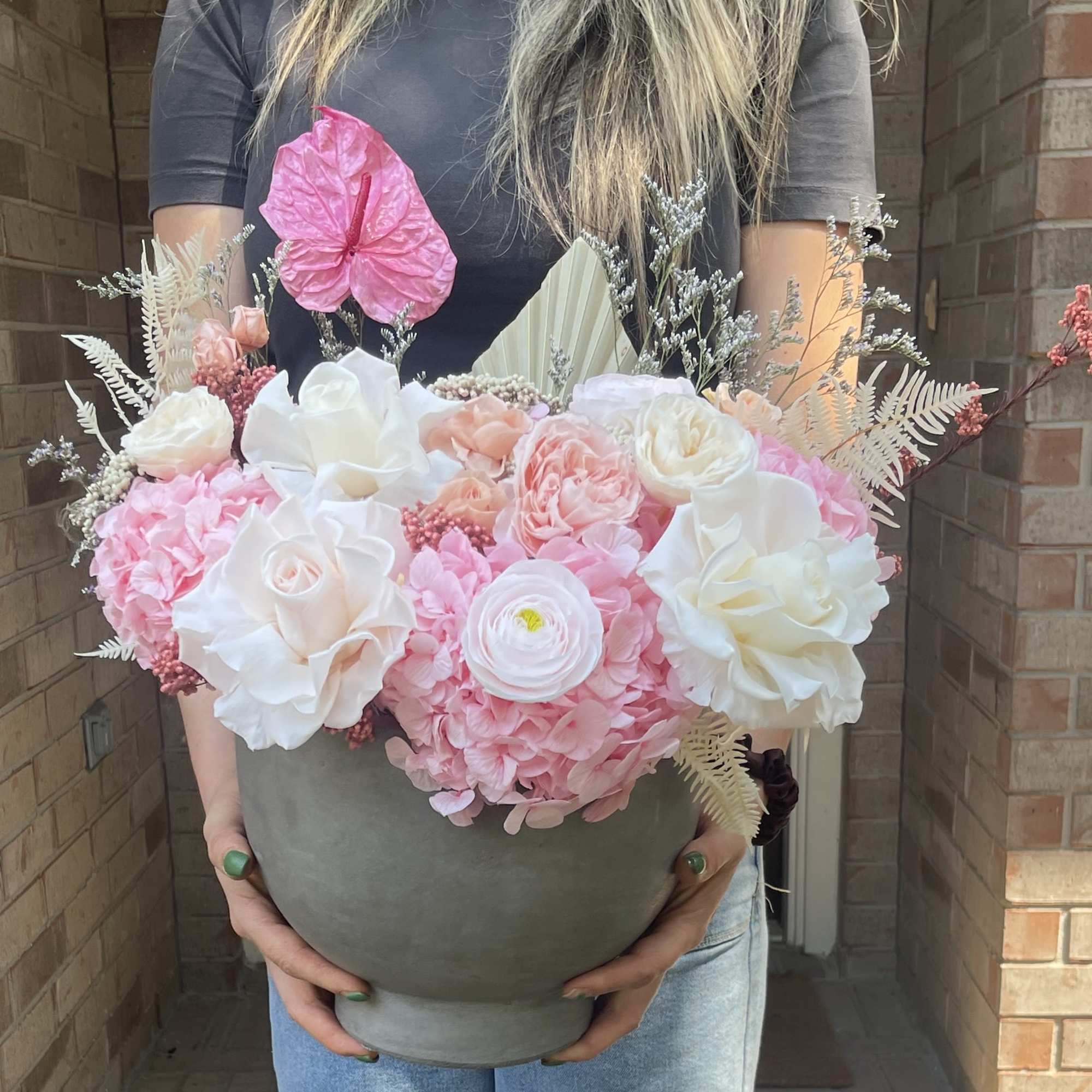 Pink and white floral arrangement in a gray vase